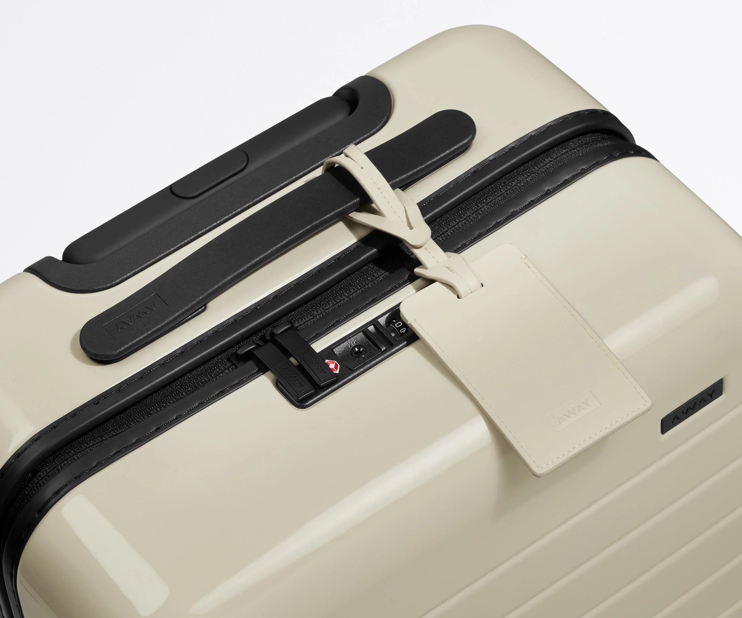 The leather luggage tag on top of a matching Away suitcase
