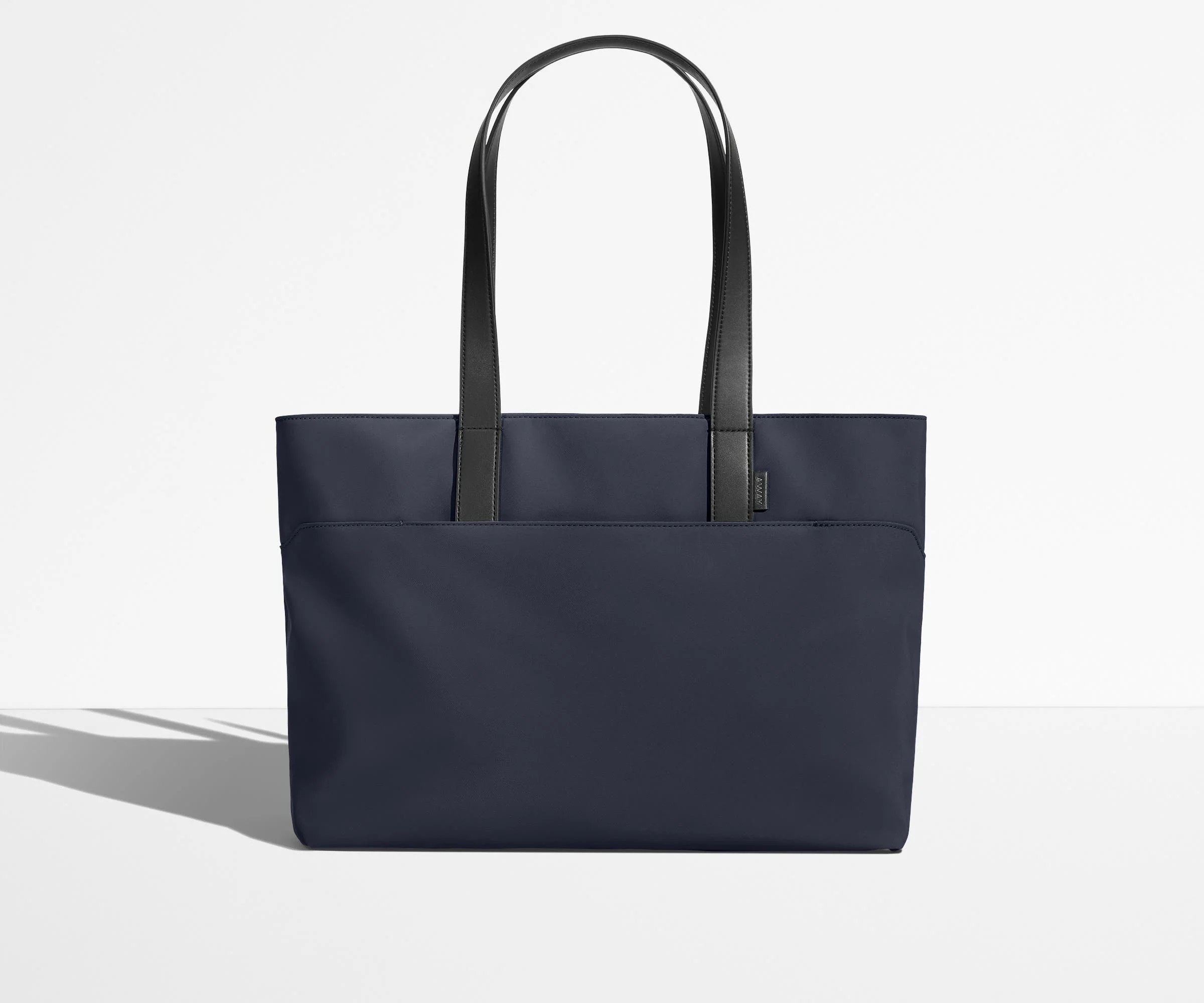 Front view of The Everywhere Tote with its leather handles up