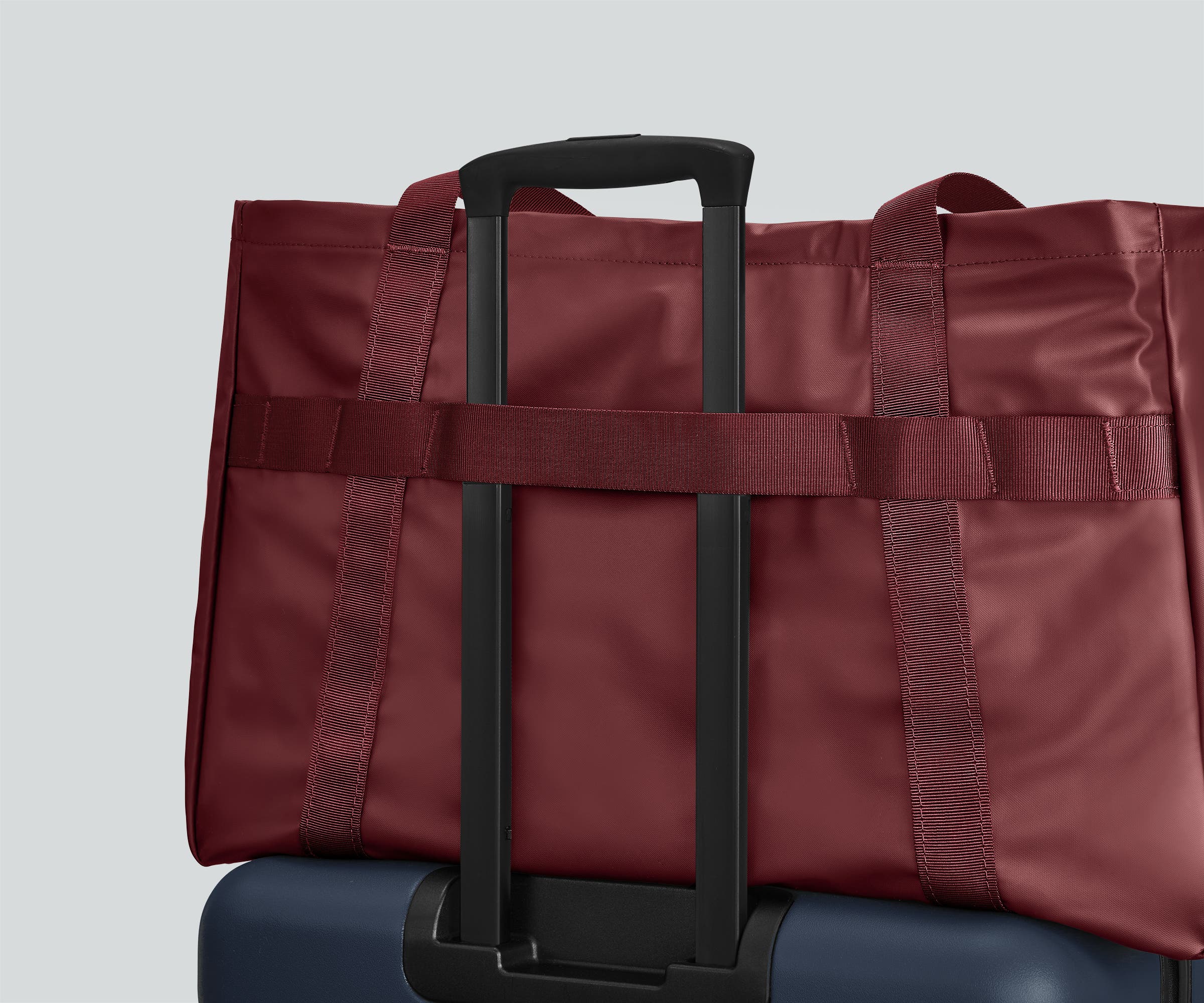 Active Tote 45L secured to an Away suitcase by its trolley strap