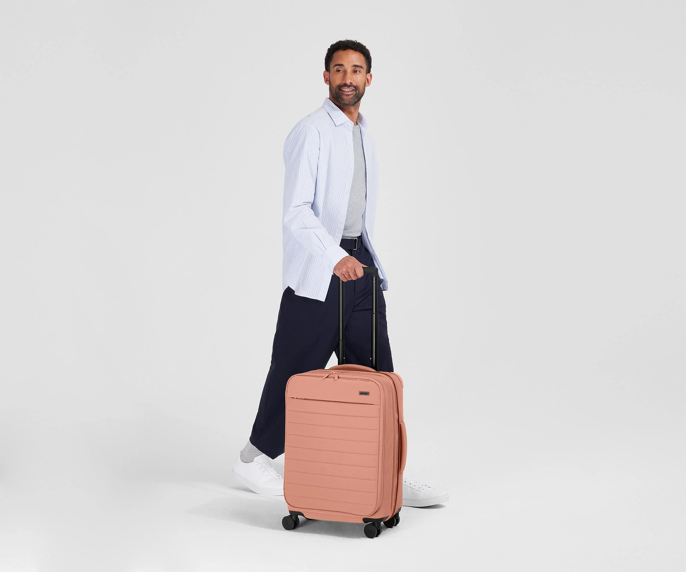 Person standing next to the Softside Bigger Carry-on for scale
