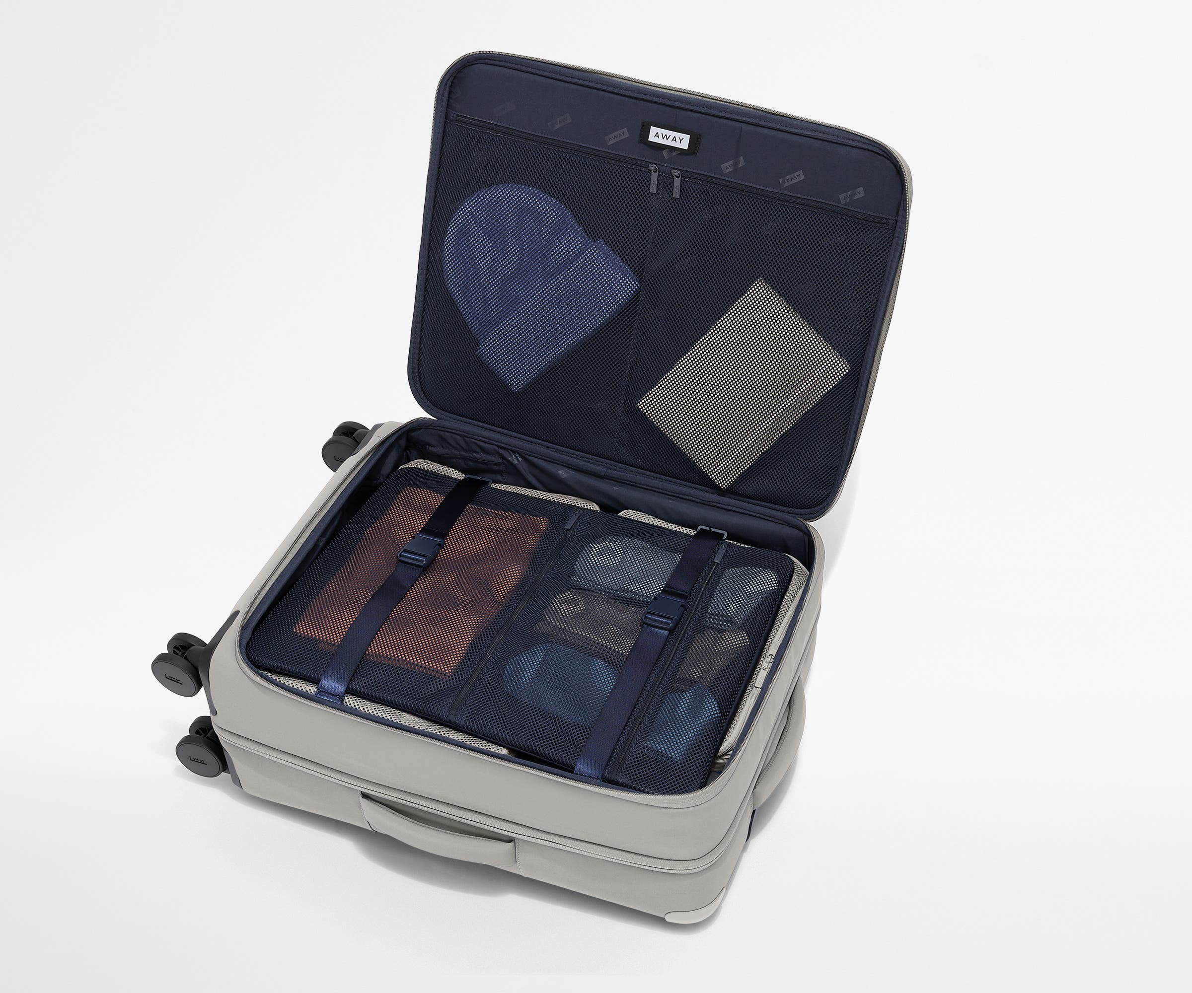 Open Softside suitcase, with travel essentials in the front flap pocket and compression pad pockets