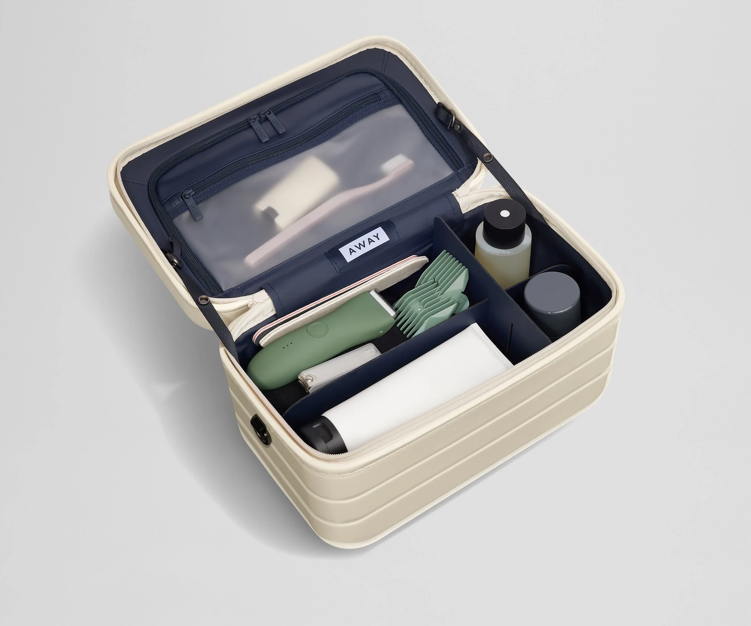 Train case packed with multiple grooming essentials, including a razor, nail care, and lotions