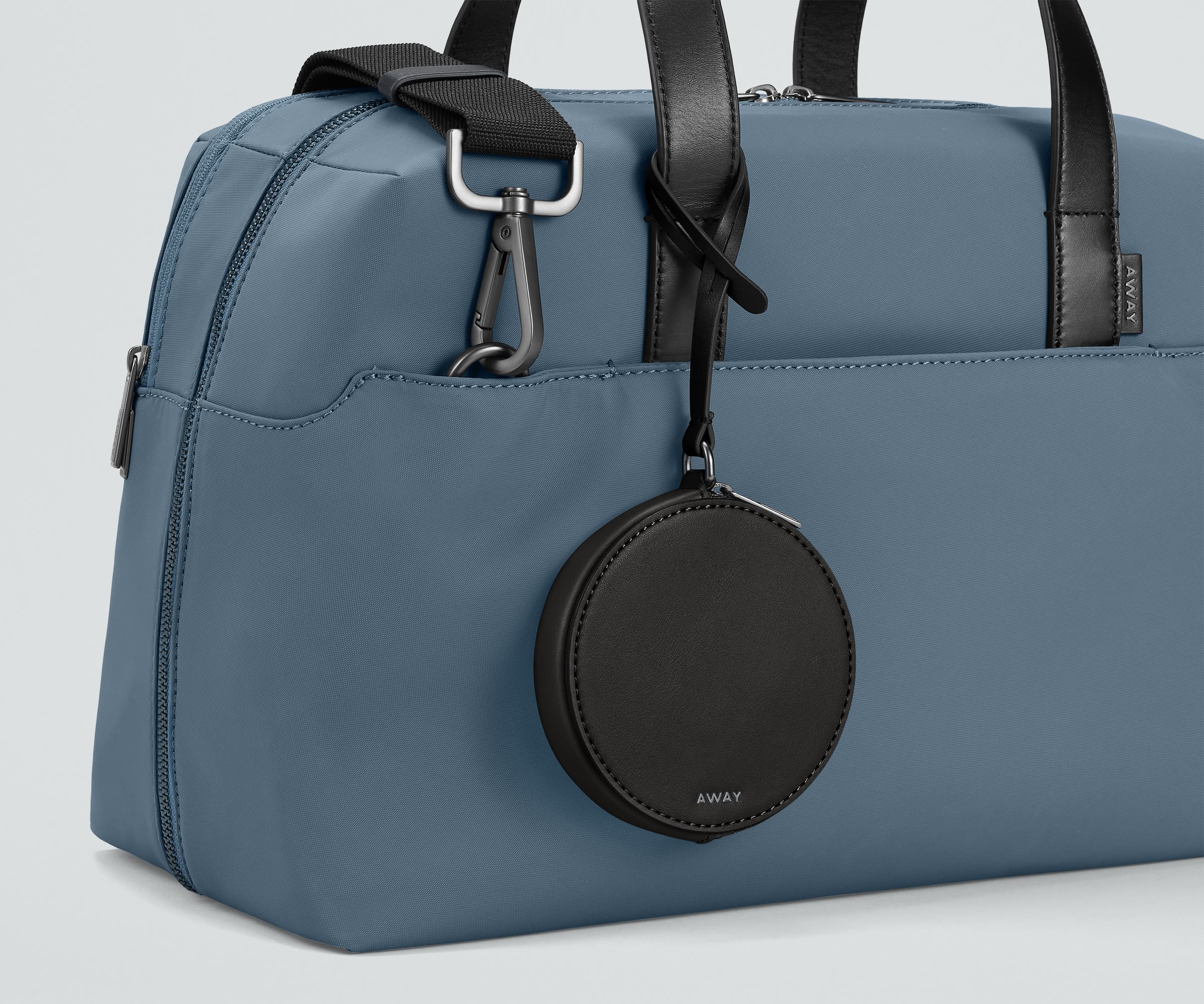 The Circle Zip Pouch looped onto the strap of The Everywhere Bag