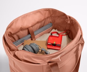 Interior packed with clothing, a laptop, headphones, notebook, and camera