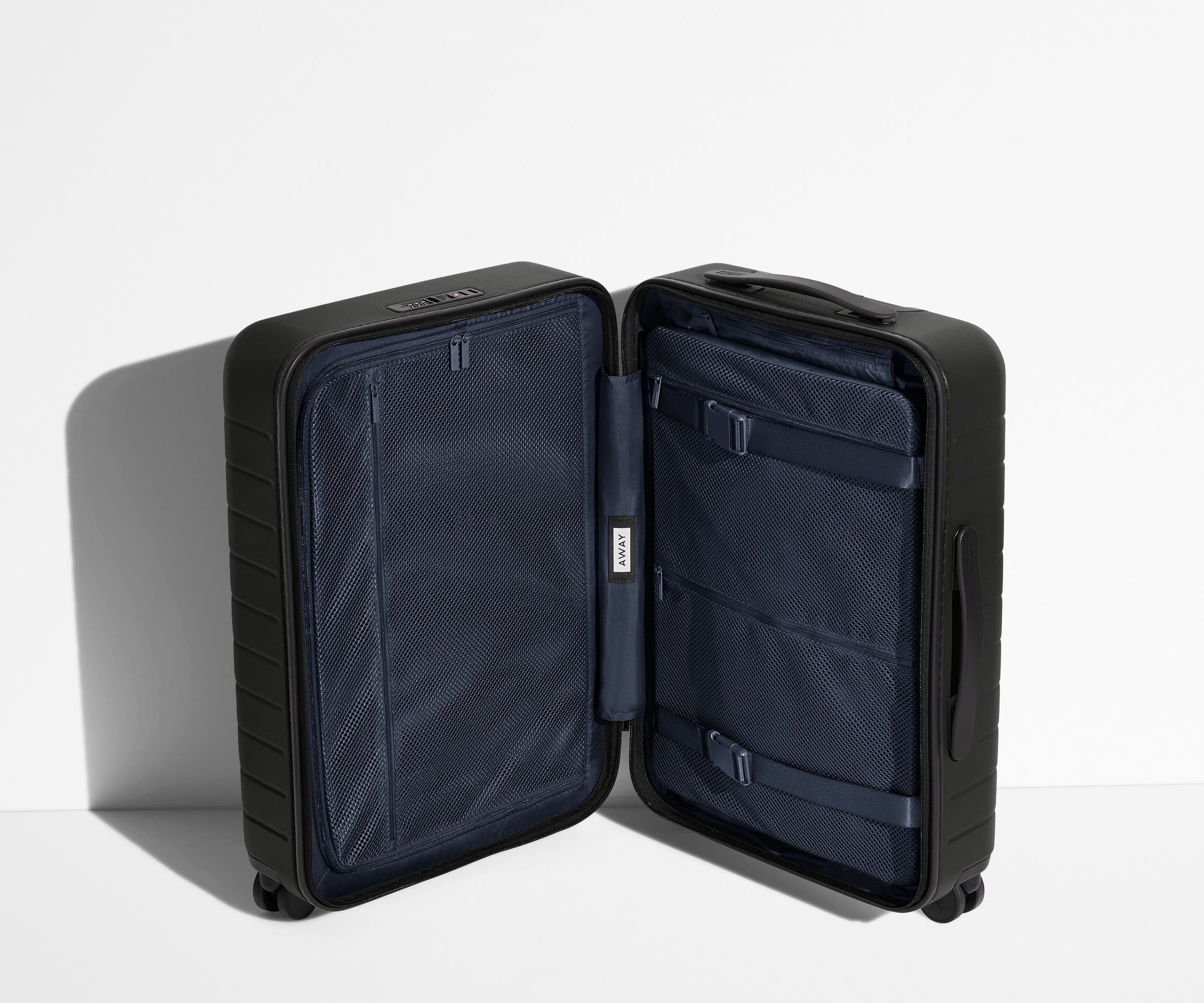 The Bigger Carry-On suitcase in Jet Black shown open in an upright position to show interior organization and compression system