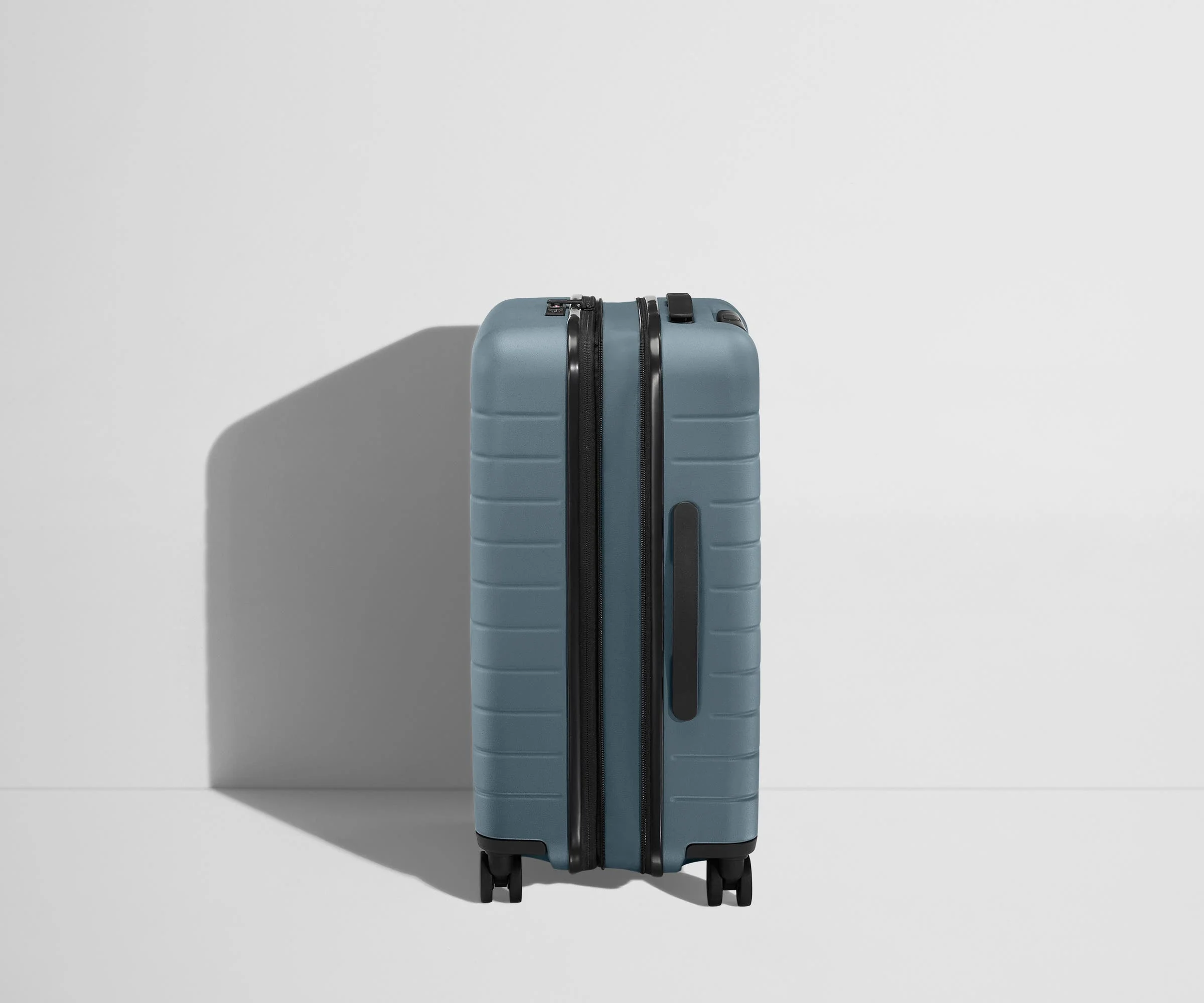 Side product view of The Bigger Carry-On Flex suitcase in Coast Blue shown fully expanded