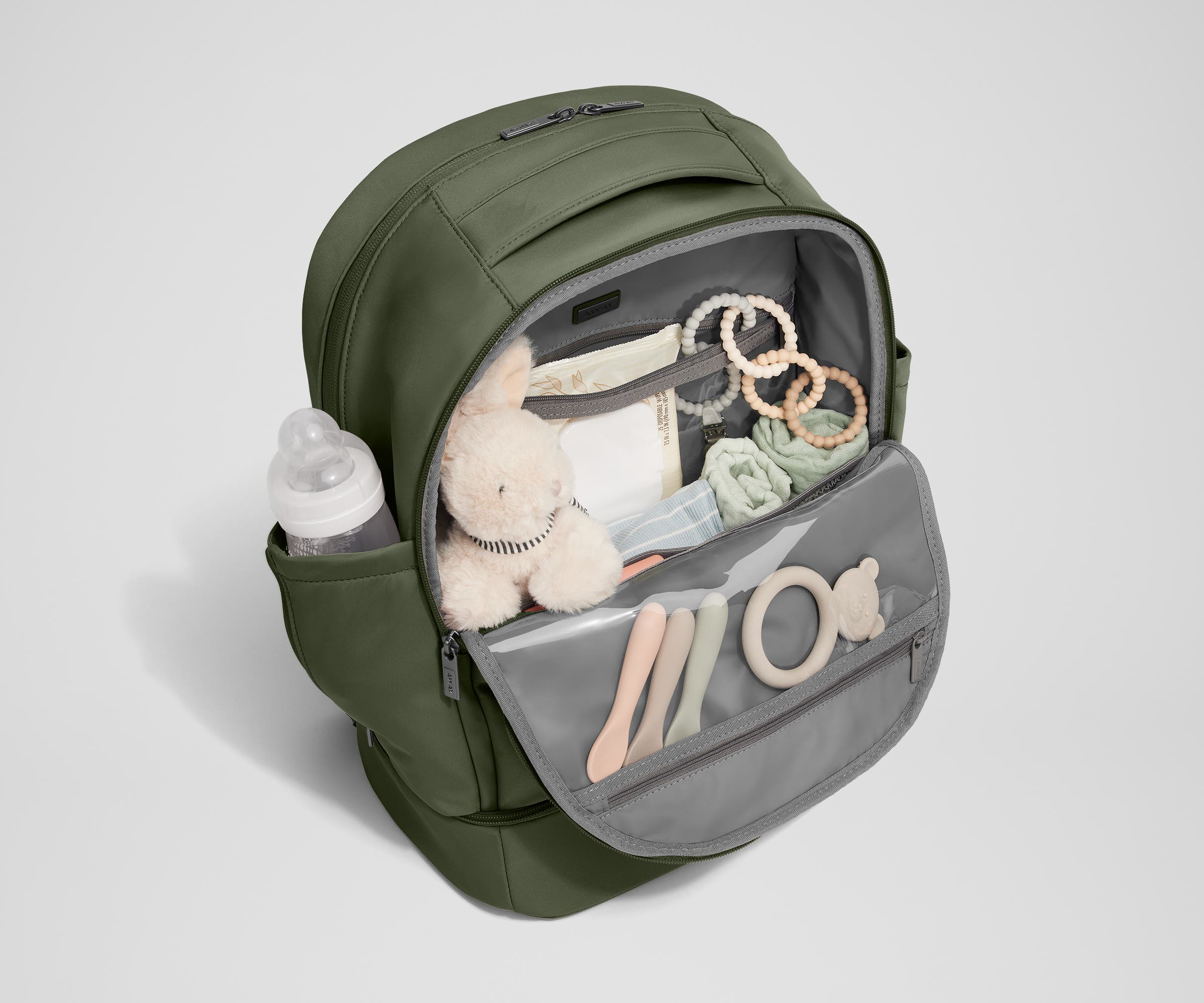 Front main compartment packed with child essentials, including a stuffed animal, wipes, and change of clothes