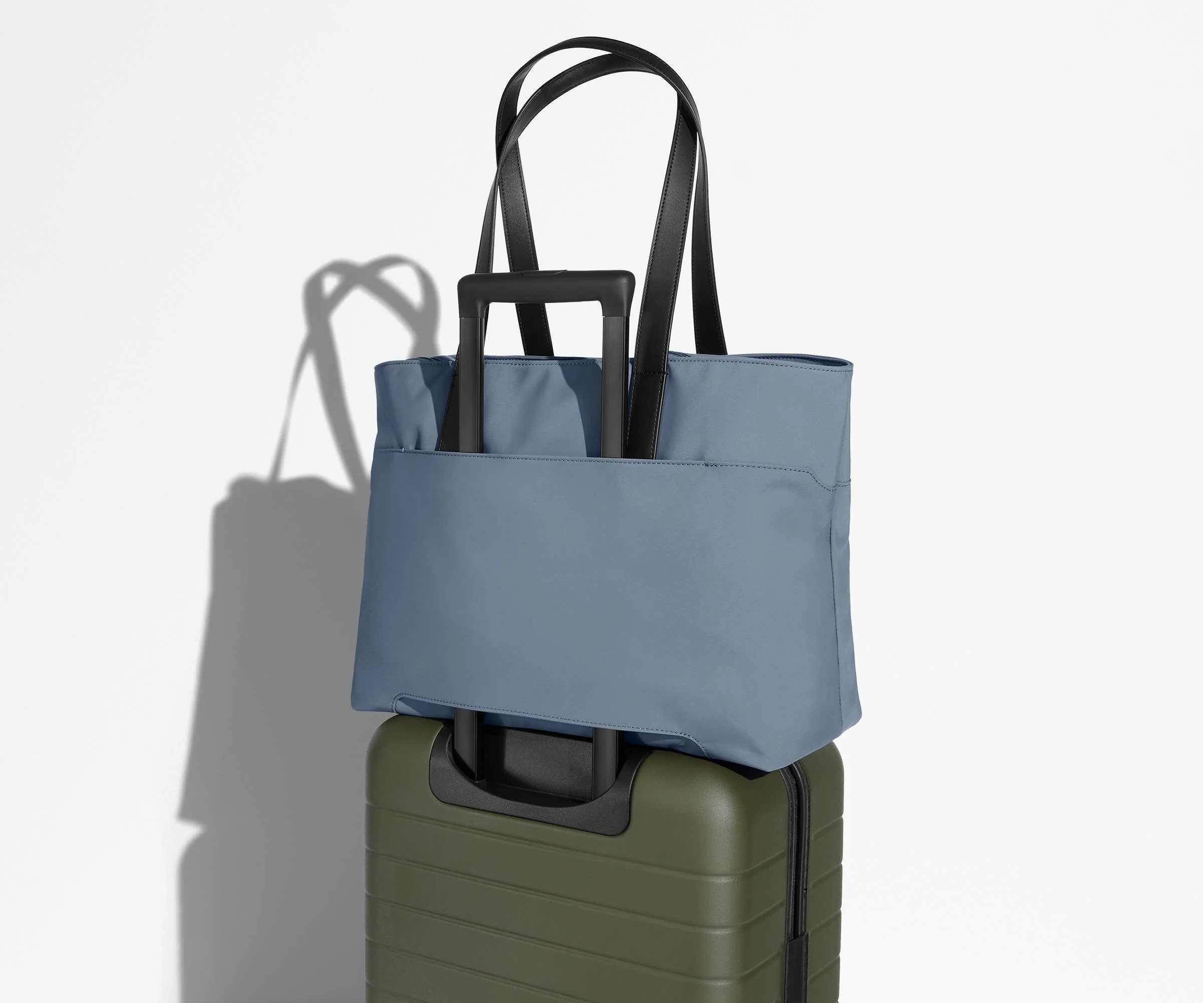 Everywhere Tote secured to an Away suitcase by its trolley sleeve