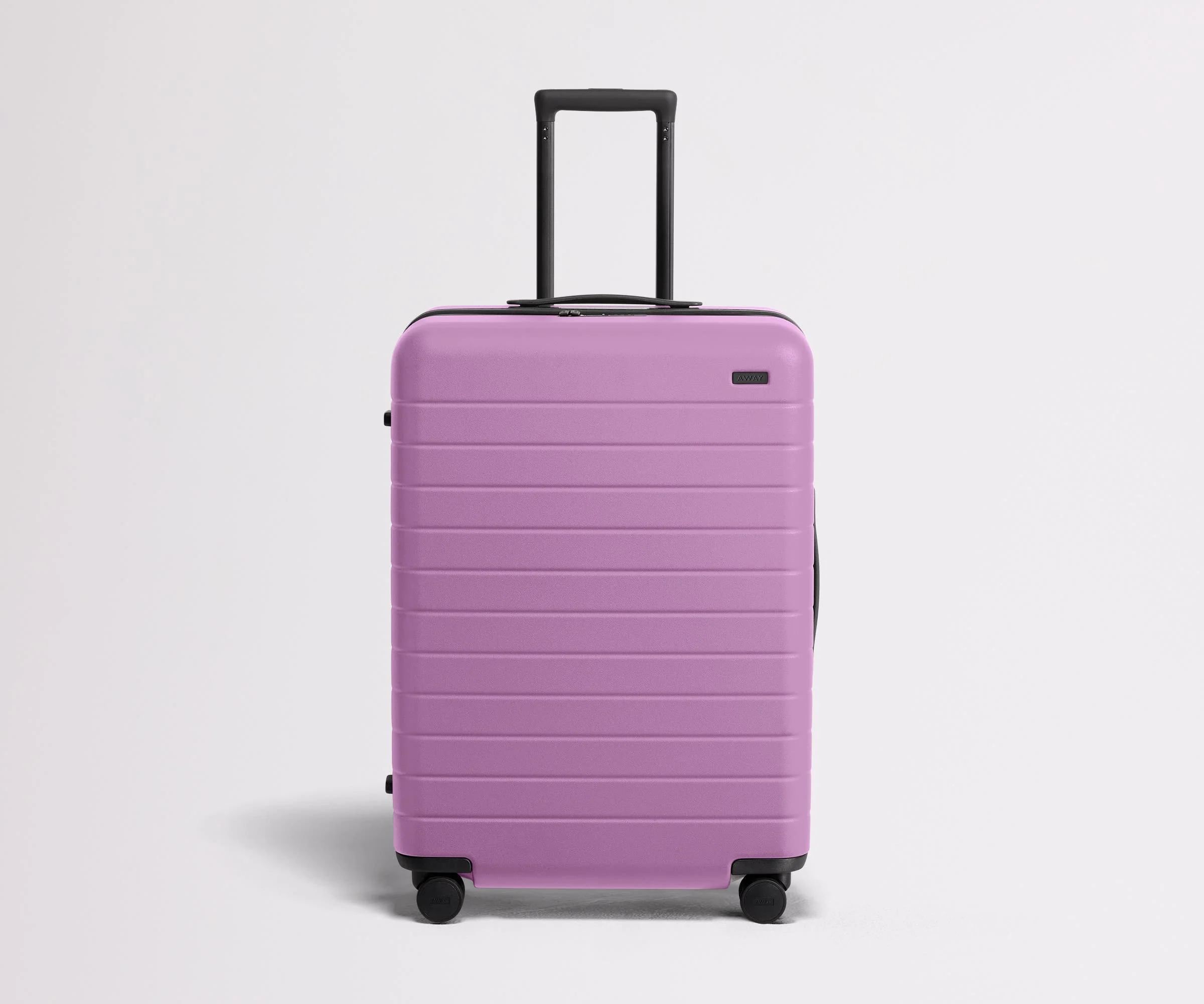 Front product view of The Medium suitcase in Taffy Purple with raised handle