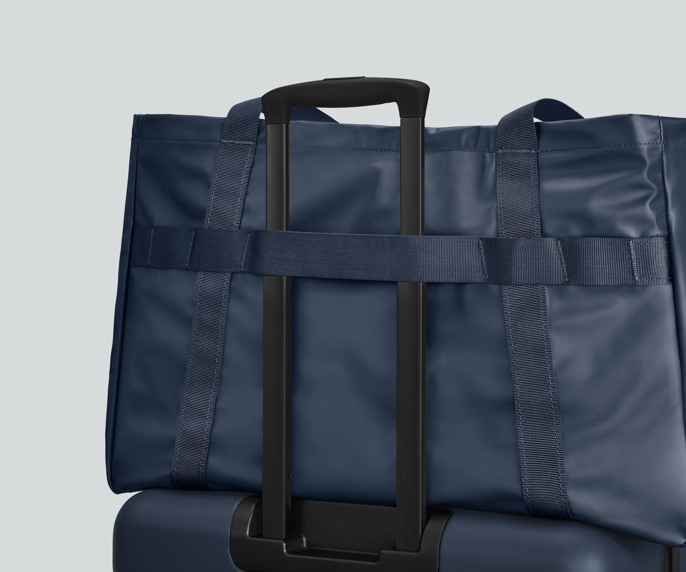 Active Tote 45L secured to an Away suitcase by its trolley strap