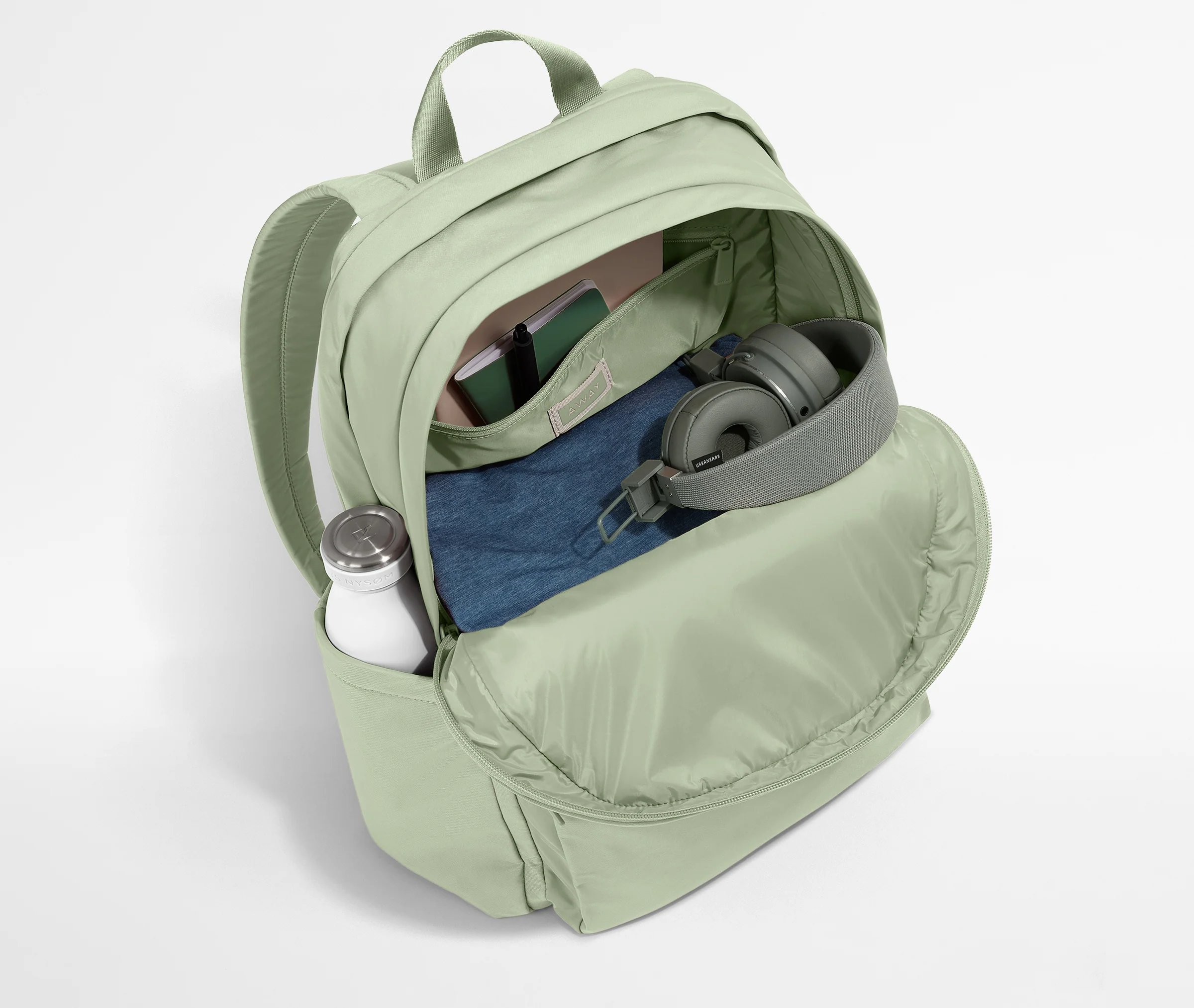 Front compartment packed with a notebooks, headphones, and clothing
