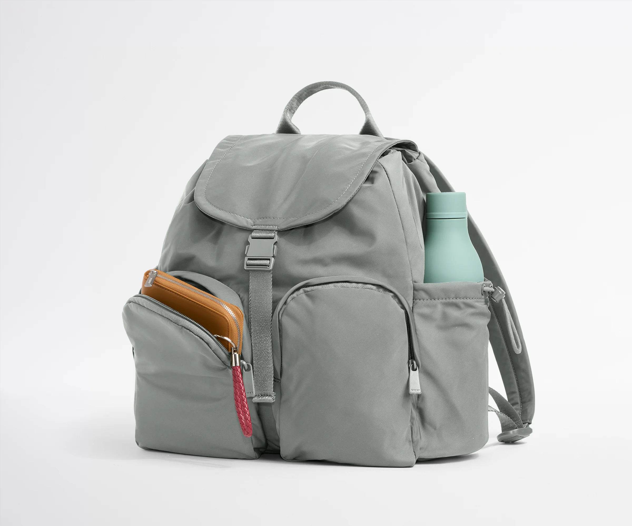 Gray backpack with a water bottle and phone case on a white background