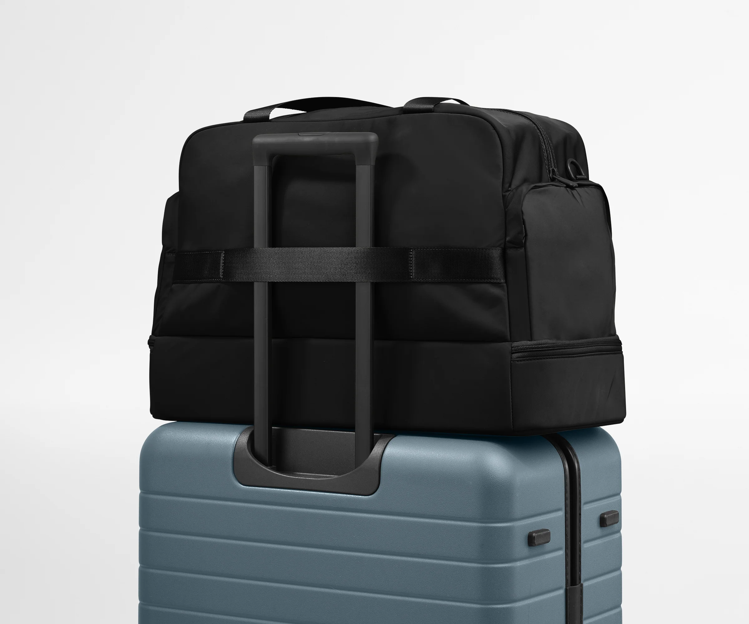 Featherlight Weekender shown on top of an Away suitcase