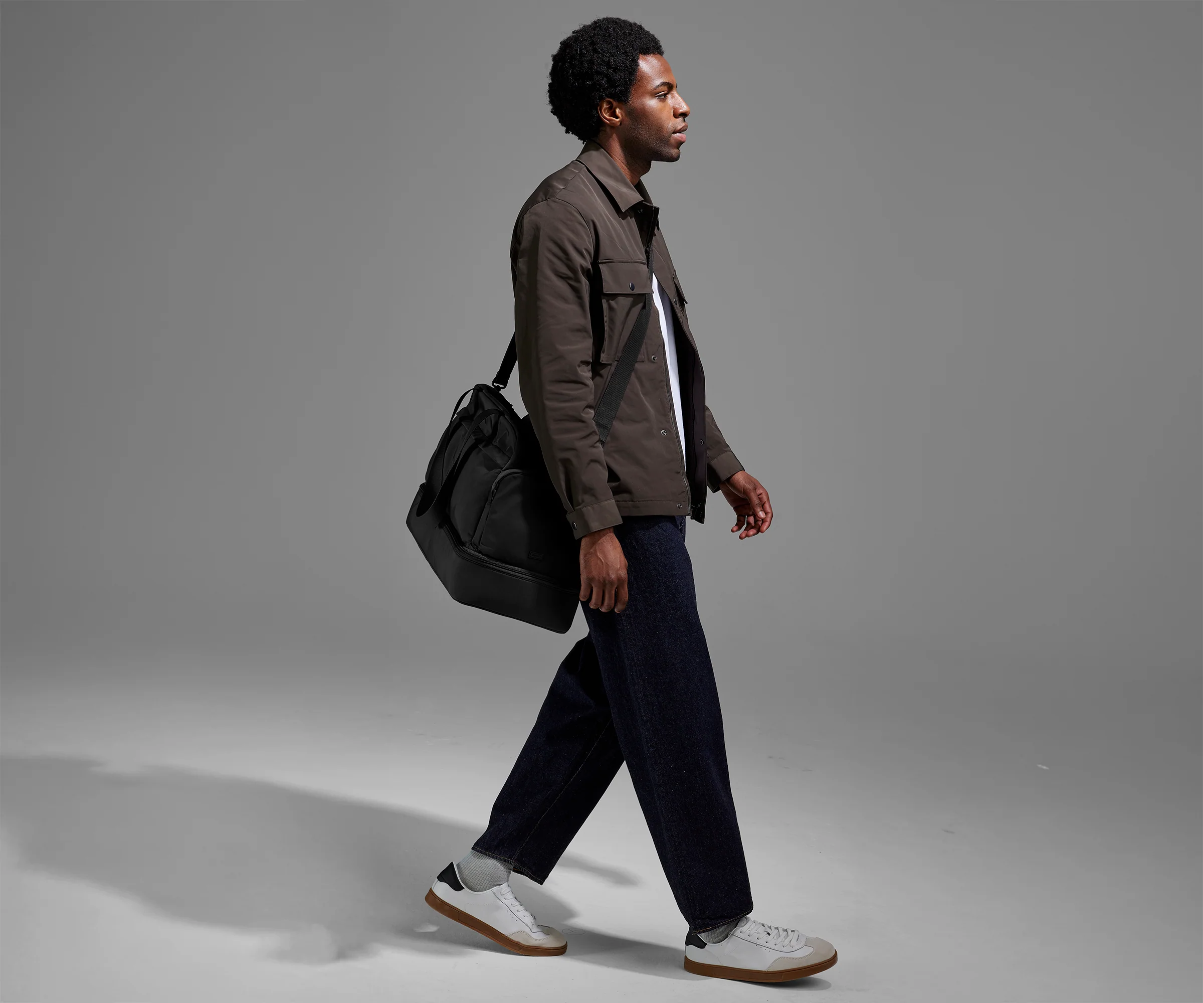 Person wearing the Featherlight Weekender as a crossbody with the detachable strap