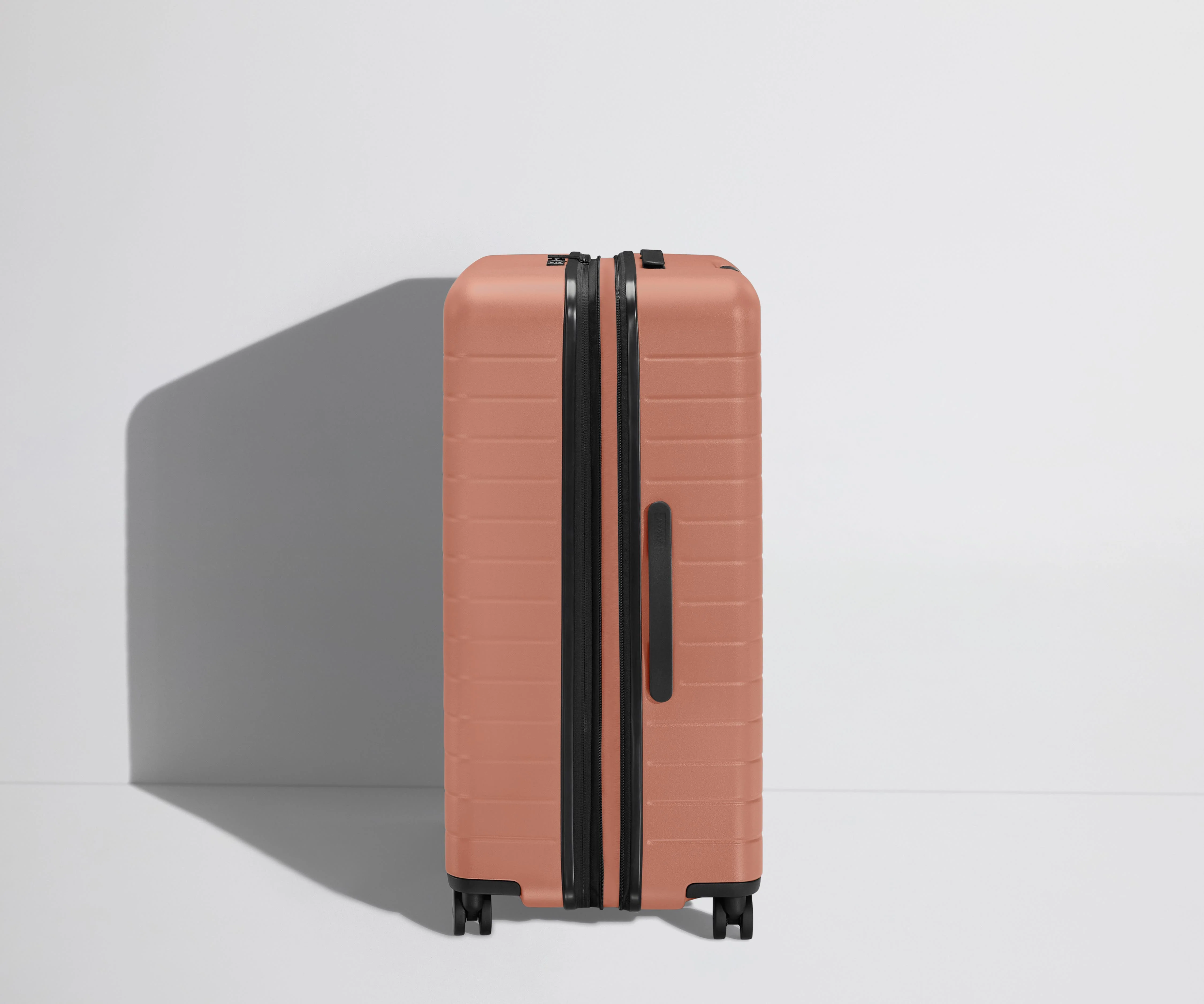 Side product view of The Large Flex suitcase in Clay Pink shown fully expanded