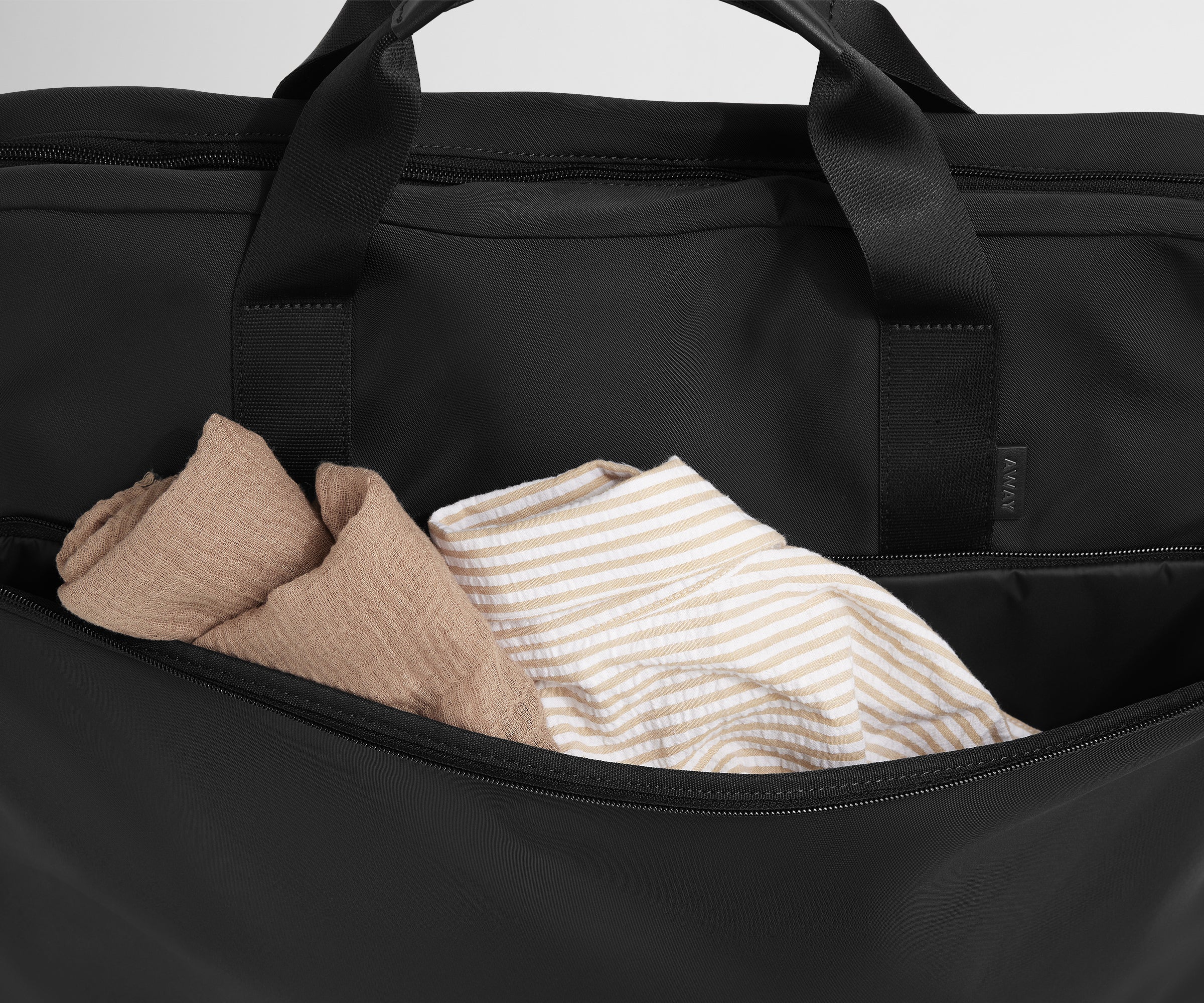 Close up of the front pocket of the Garment Bag in Jet Black to show more space to pack extra clothes