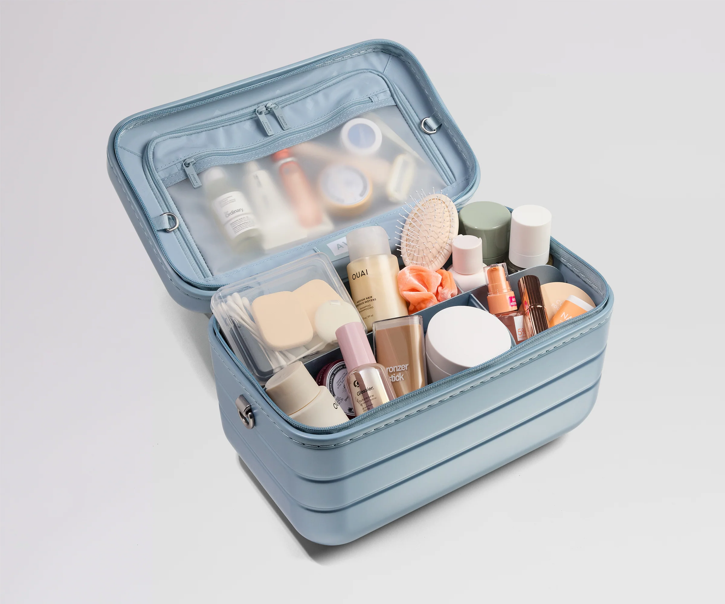 Blue makeup case with various cosmetic products on a light gray background