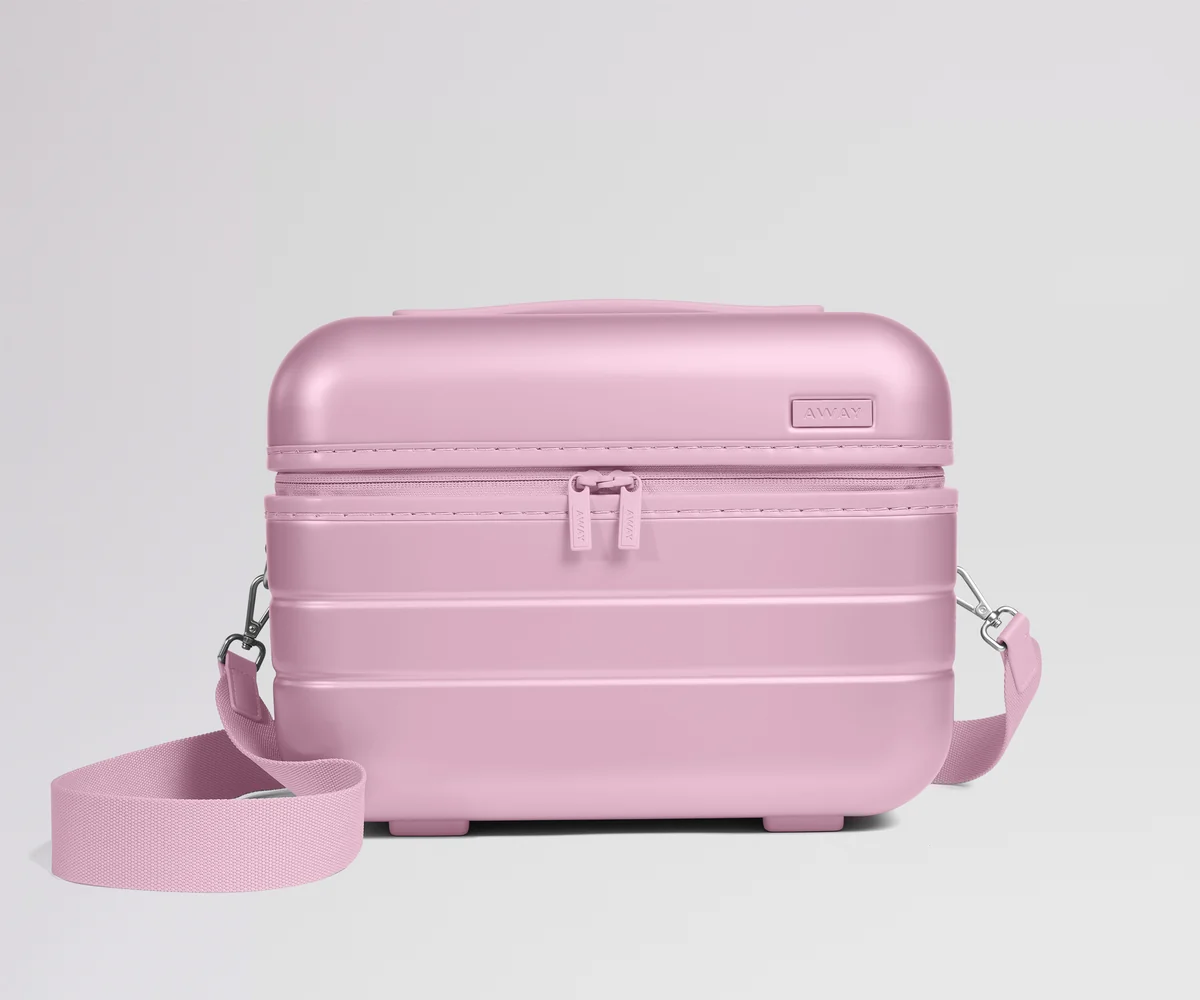 Pink travel case with a strap on a light gray background