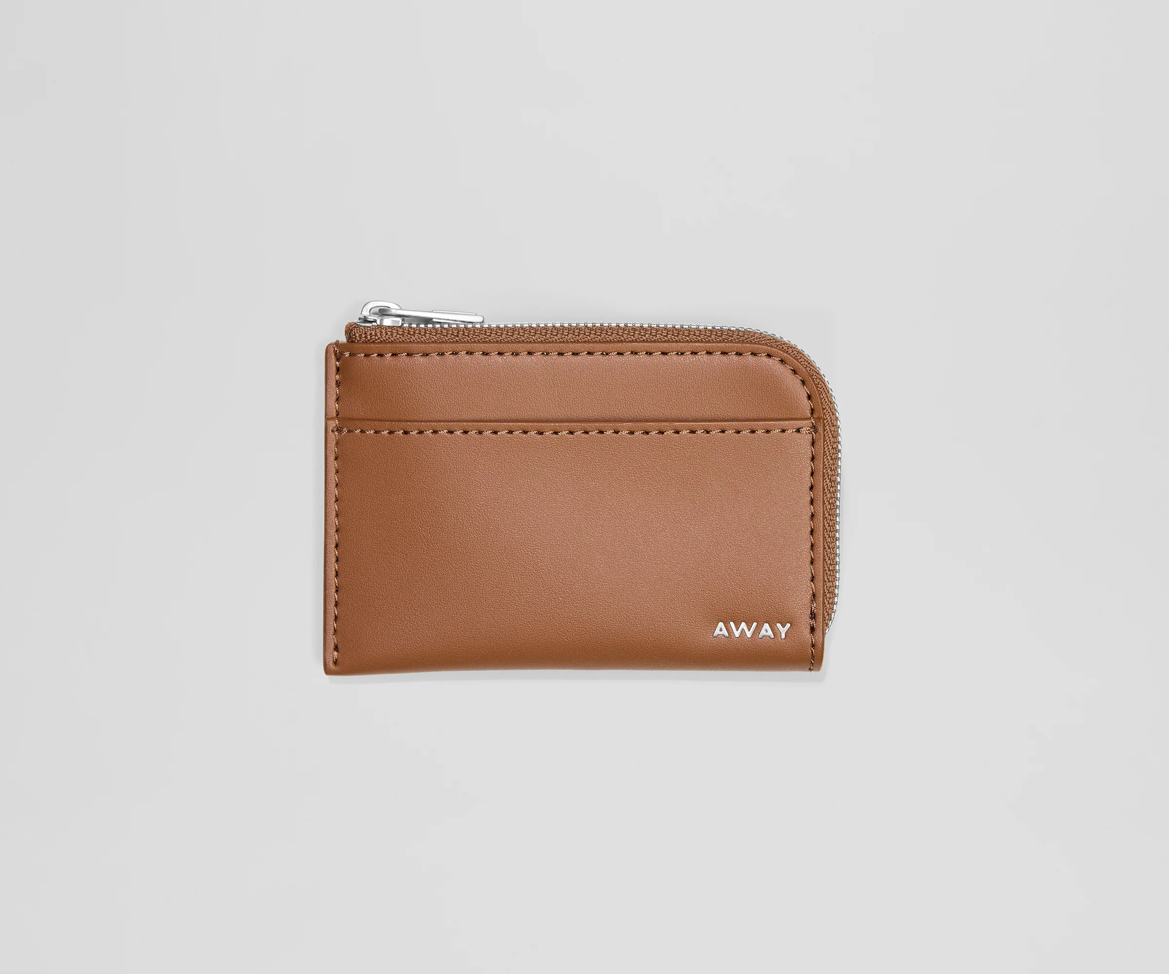 Brown leather cardholder with 'AWAY' branding on a light gray background