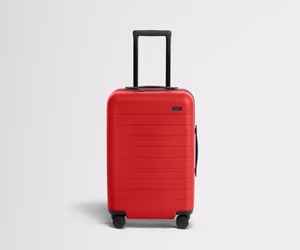 Red suitcase with a black handle on a light gray background