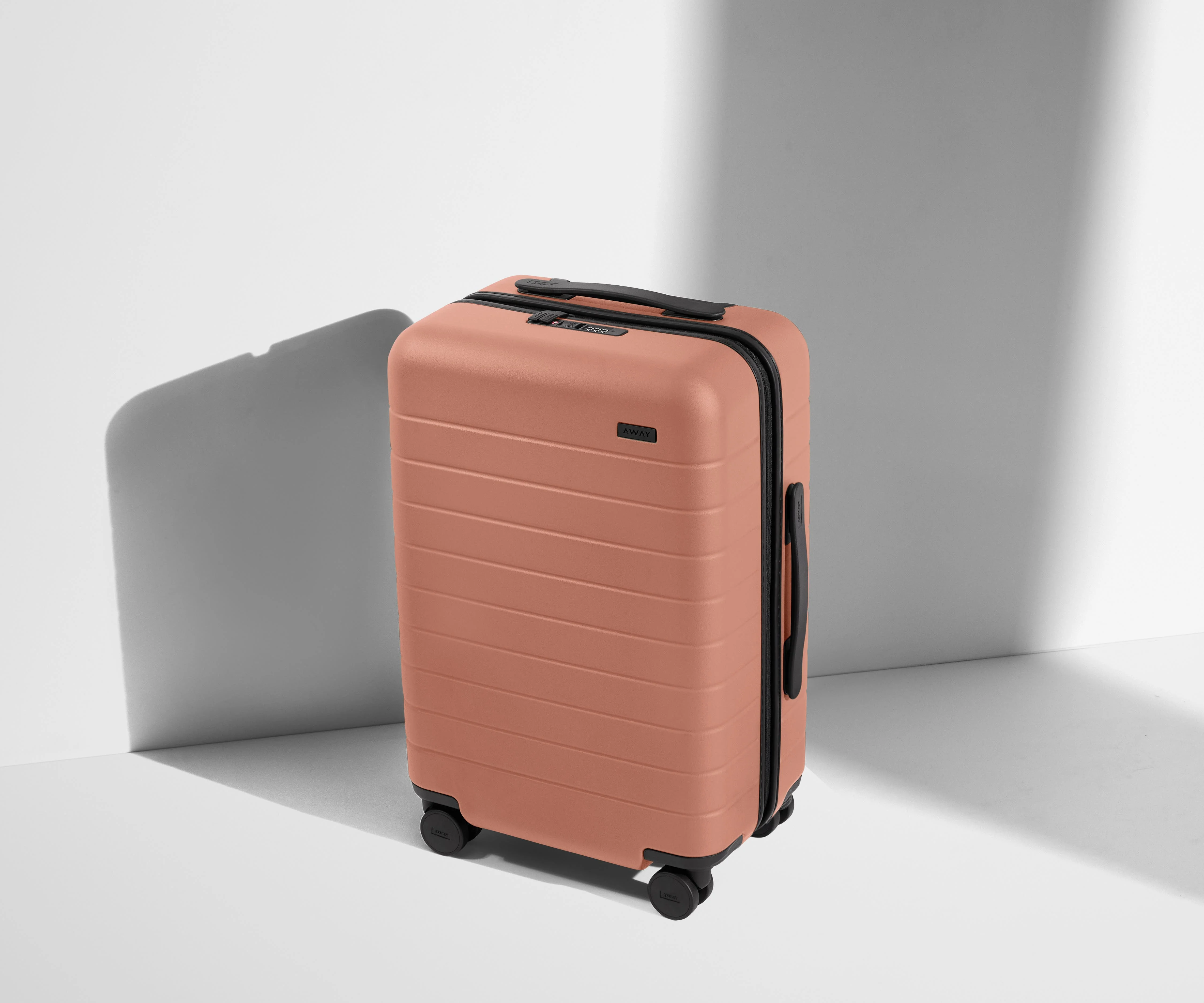 Angled product view of The Carry-On suitcase in Clay Pink