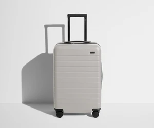 Front product view of The Bigger Carry-On suitcase in Cloud Gray with raised handle