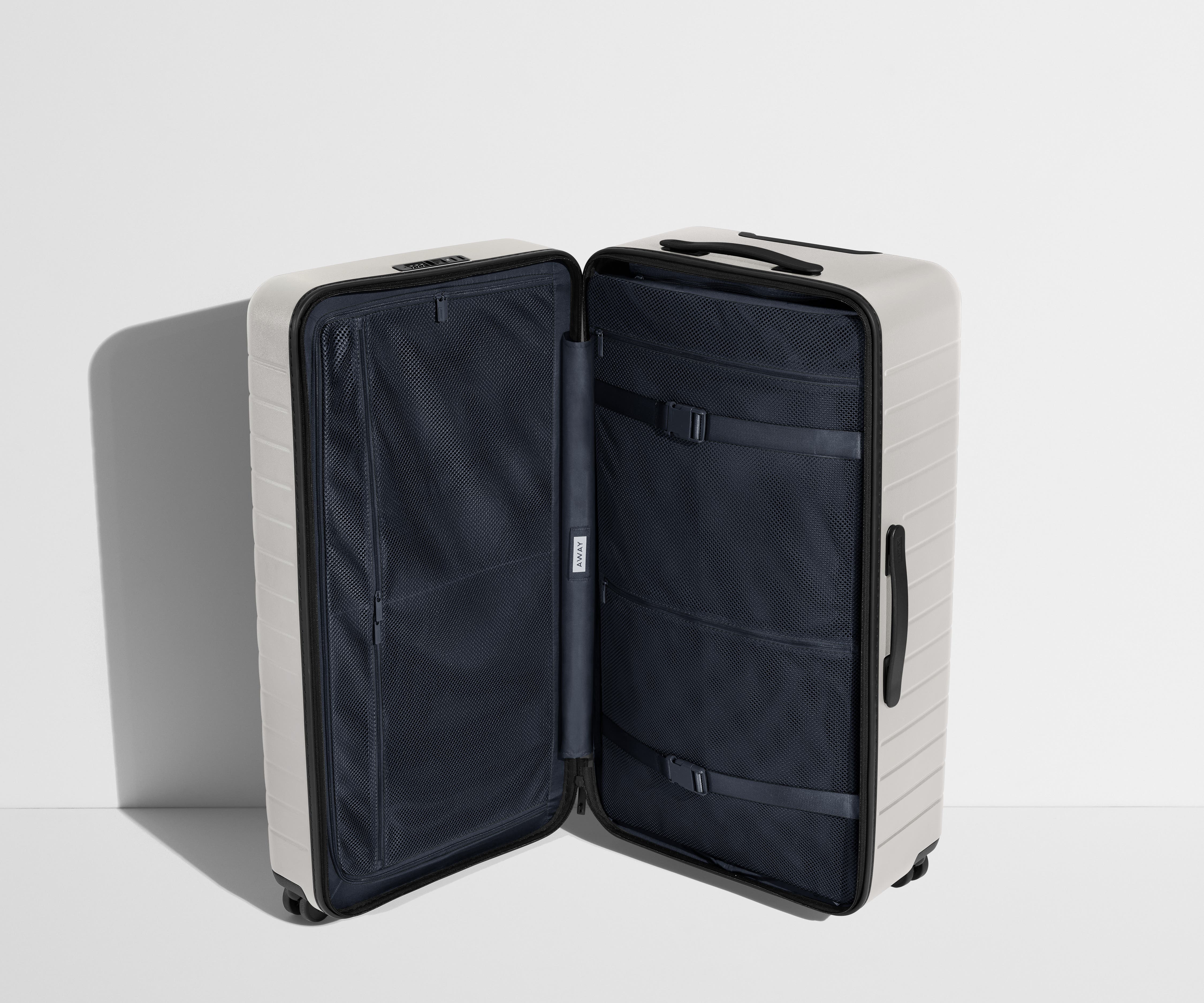 The Trunk suitcase in Cloud Gray shown open in an upright position to show interior organization and compression system