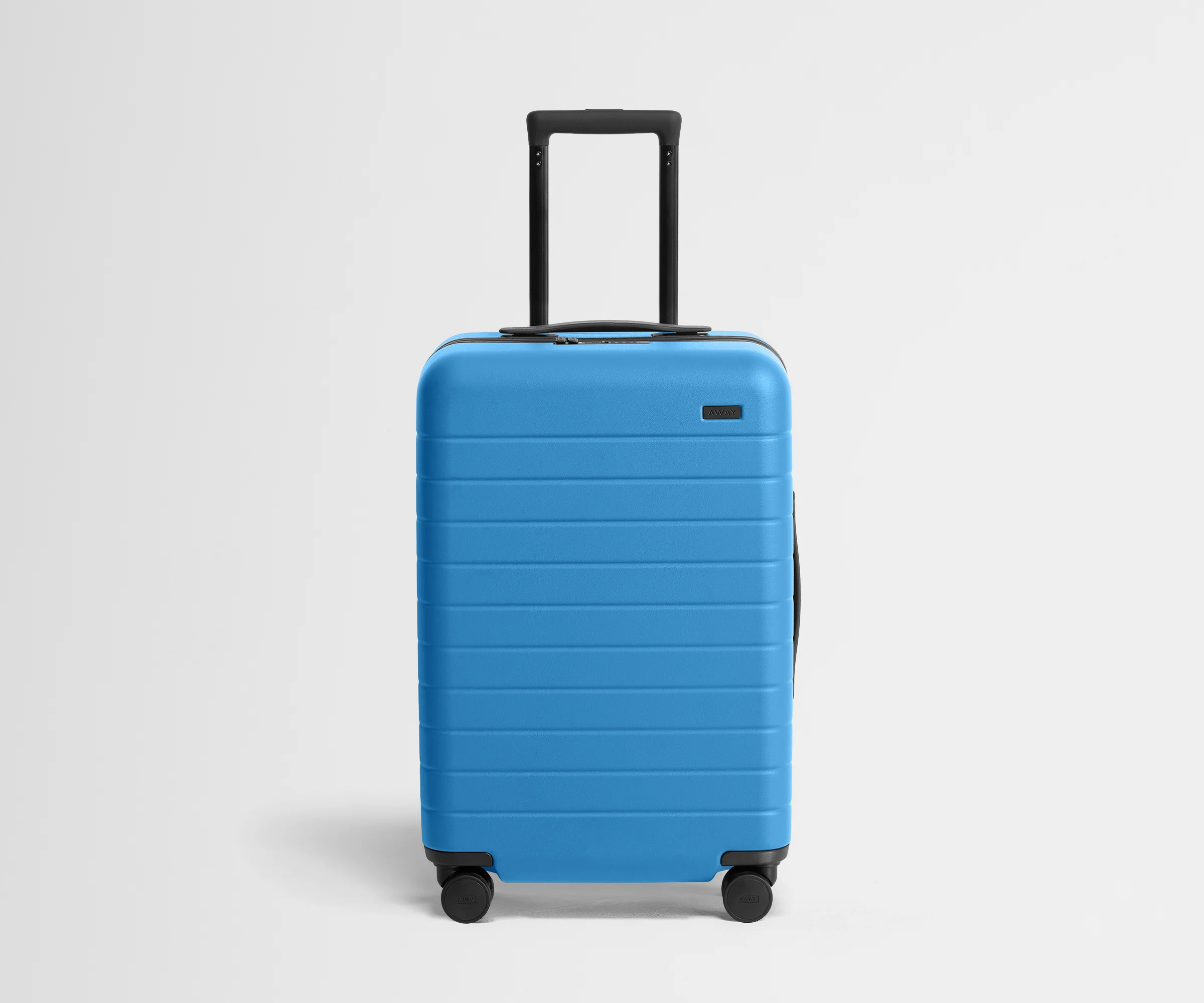 Front product view of The Bigger Carry-On suitcase in Splash Blue with raised handle