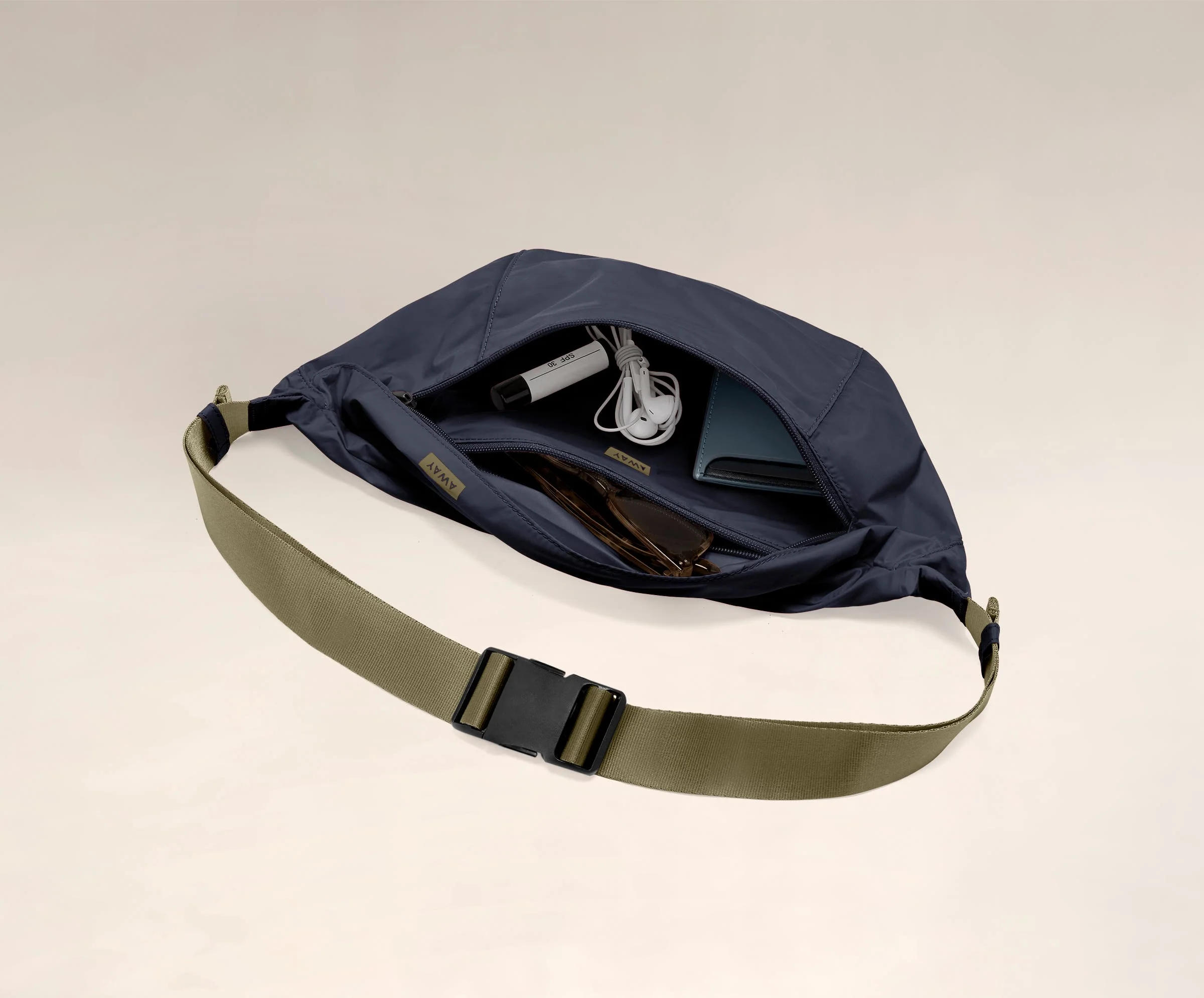 Main compartment packed with a wallet, headphones, and sunglasses