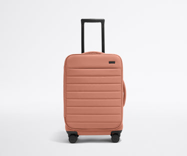 Front product view of The Softside Carry-On suitcase in Clay Pink with raised handle