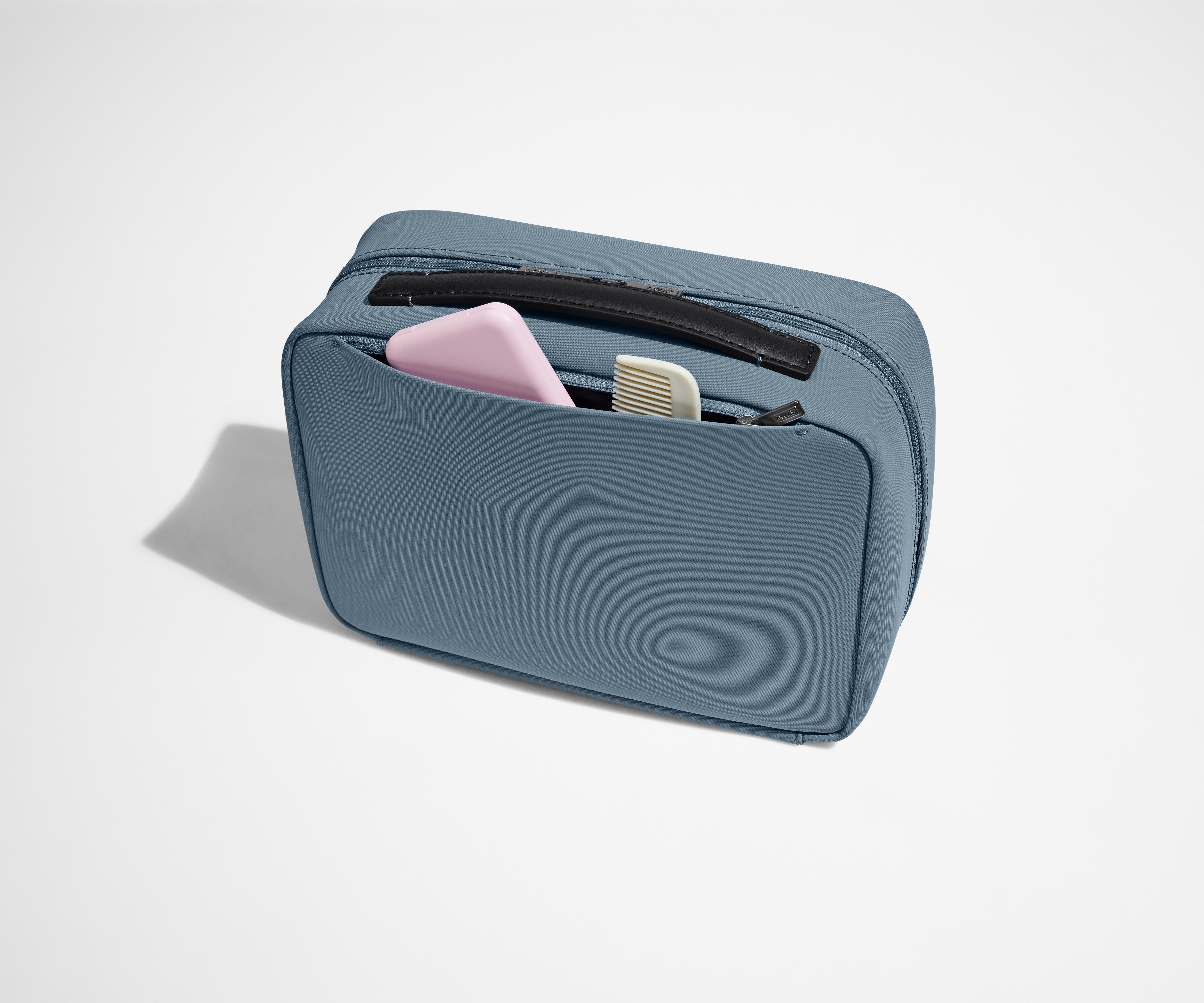 Exterior zip pocket packed with a comb and other toiletries