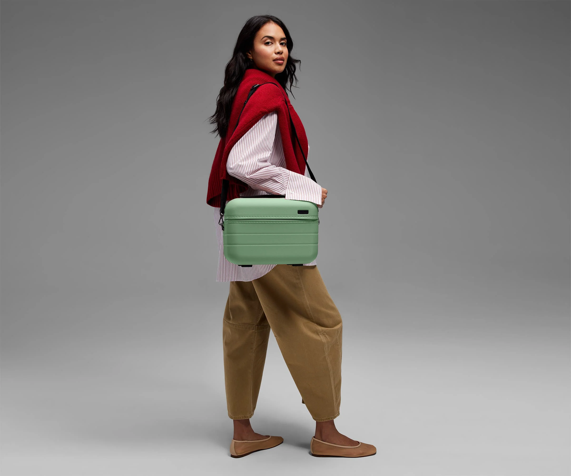 Person wearing the Train Case on their shoulder using the detachable shoulder strap
