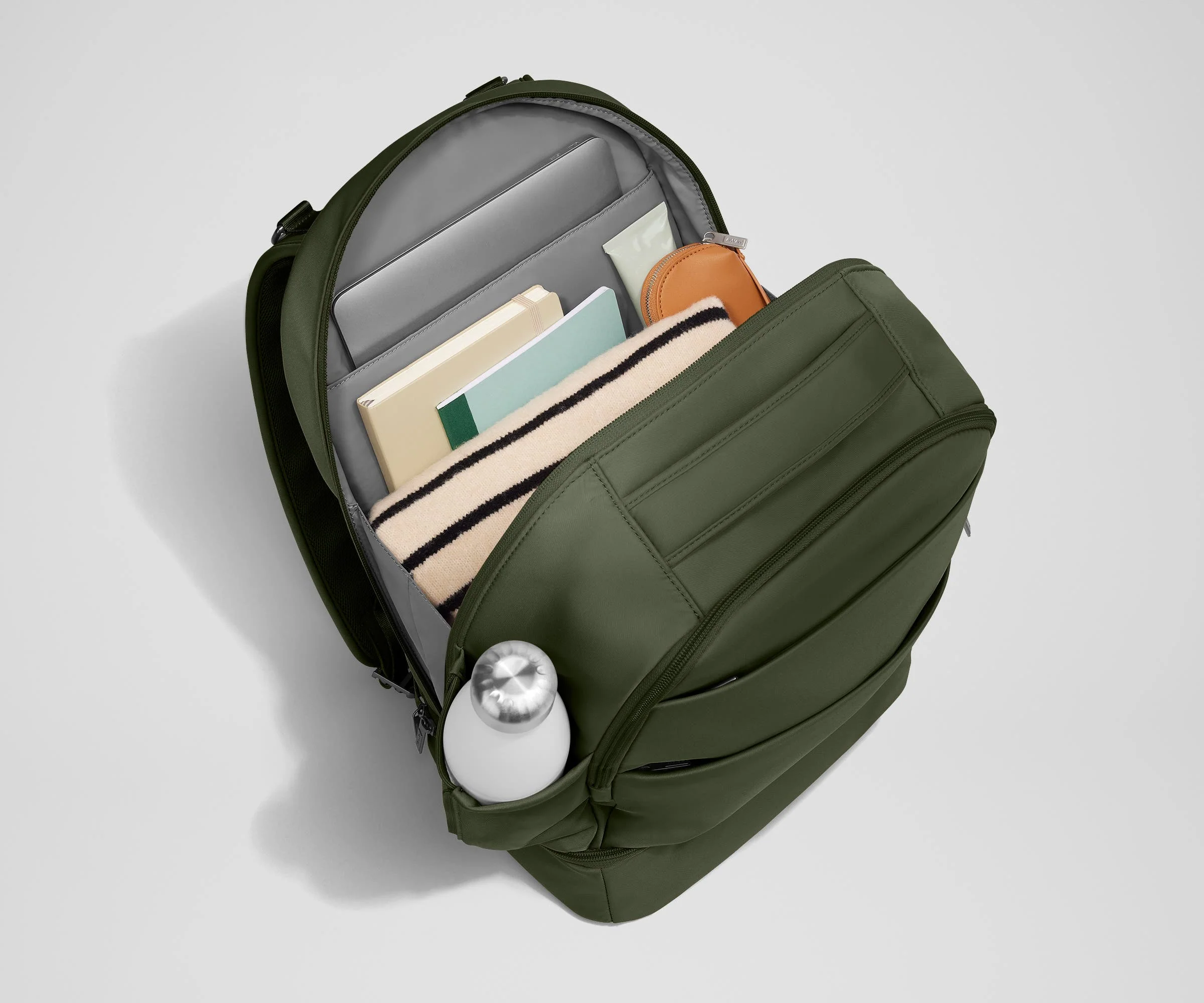 Back main compartment packed with adult travel essentials, including a laptop, notebook, and extra clothes