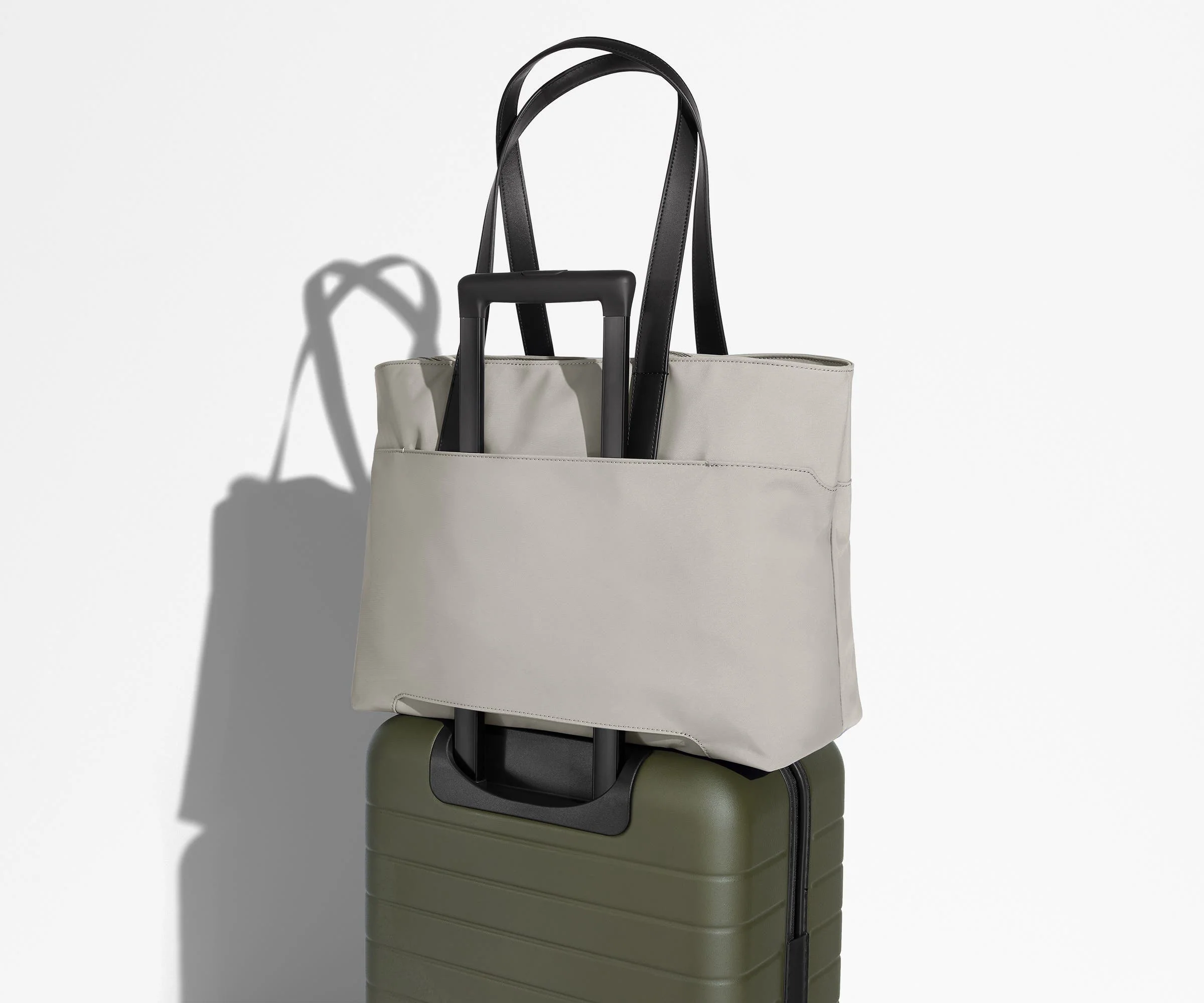 Everywhere Tote secured to an Away suitcase by its trolley sleeve