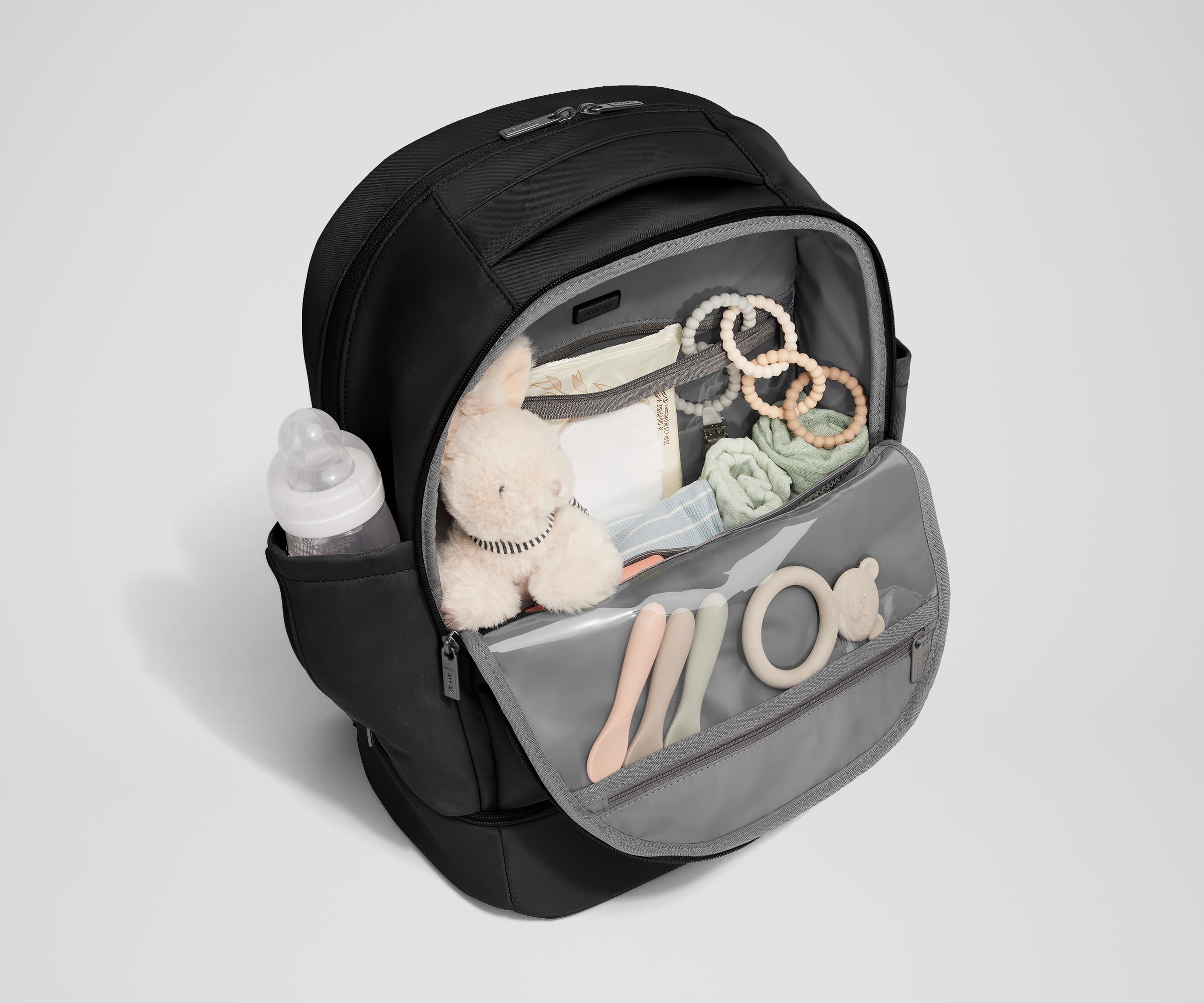 Front main compartment packed with child essentials, including a stuffed animal, wipes, and change of clothes