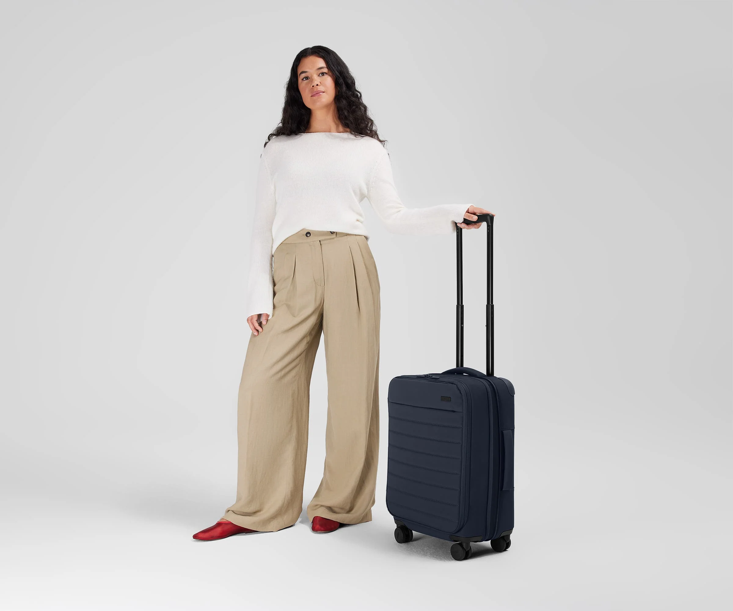 5'7" person standing next to the Softside Carry-on for scale