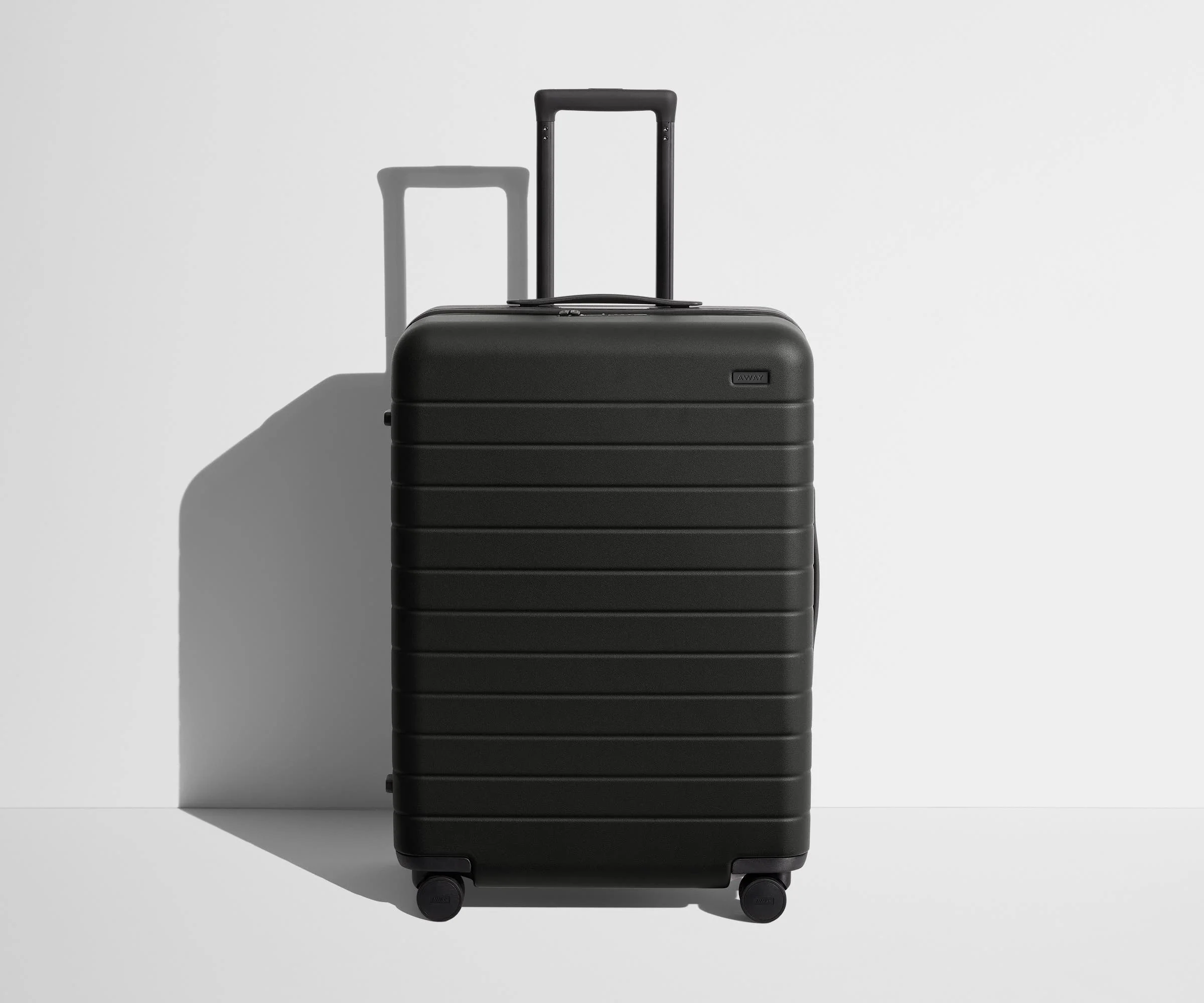 Front product view of The Medium suitcase in Jet Black with raised handle