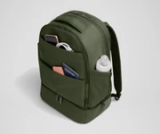 Exterior front pockets packed with travel essentials like a passport and phone, and the exterior bottle pocket packed with a milk bottle
