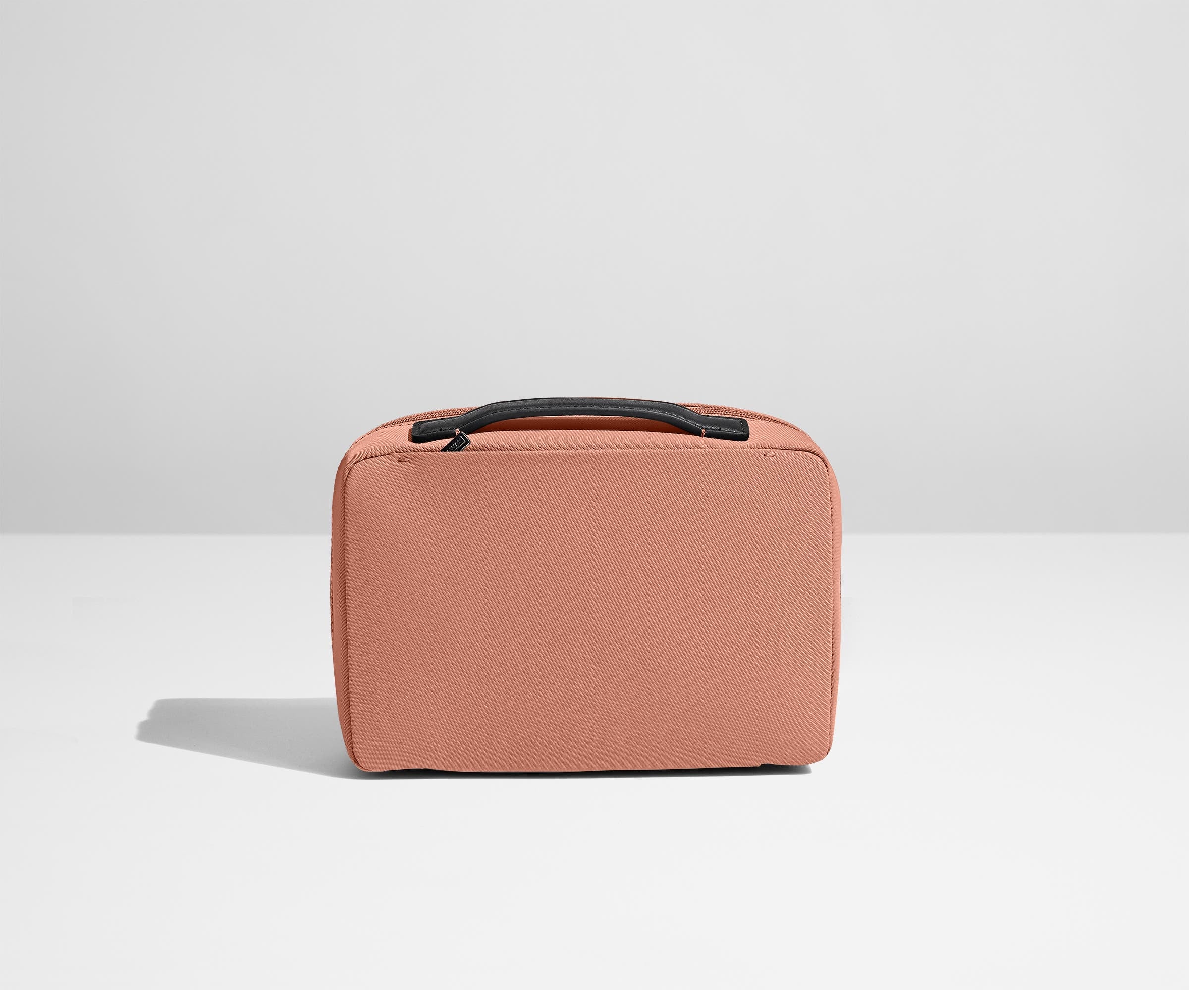 Small Toiletry Bag packed with a comb, skincare, and other travel-sized toiletries