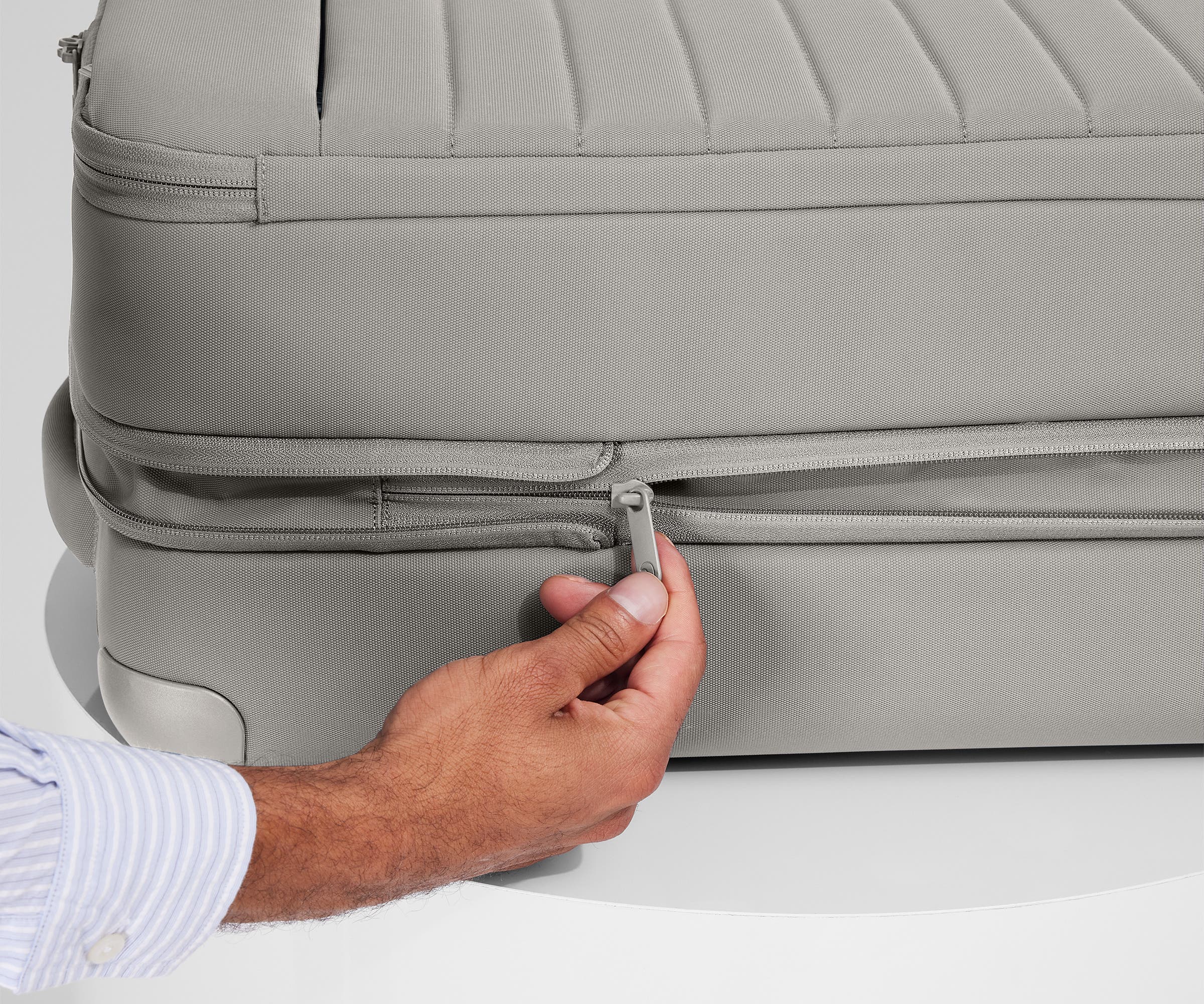 Person expanding the bag, using the wraparound zipper