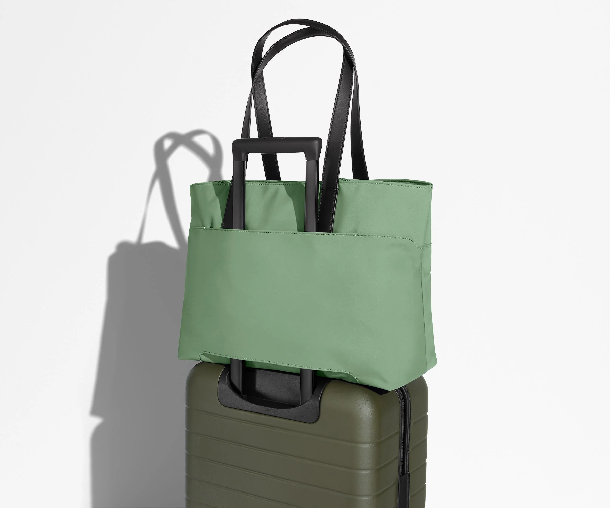 Everywhere Tote secured to an Away suitcase by its trolley sleeve